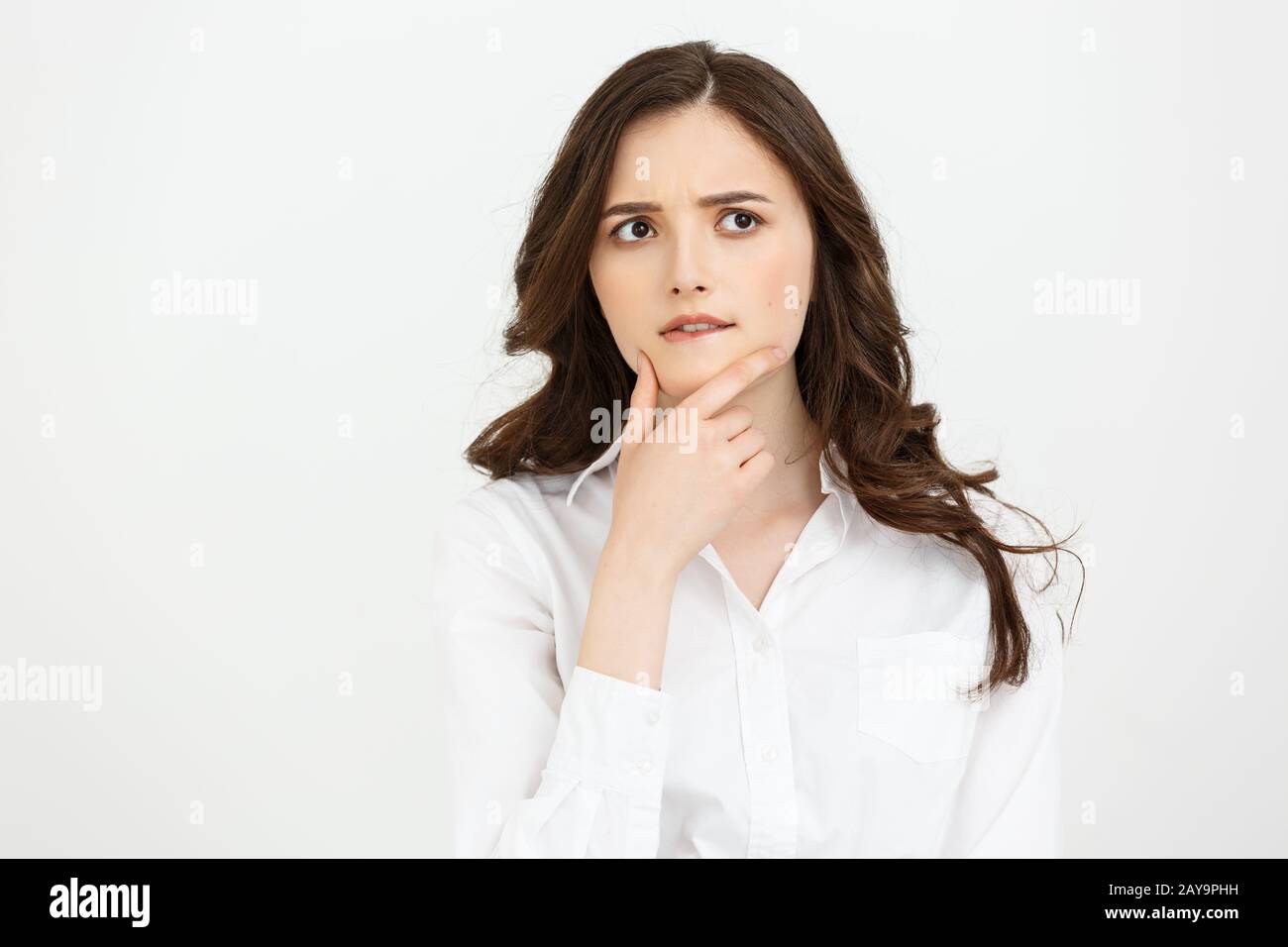 Thinking Caucasian business woman with hand on her chin and looking up ...