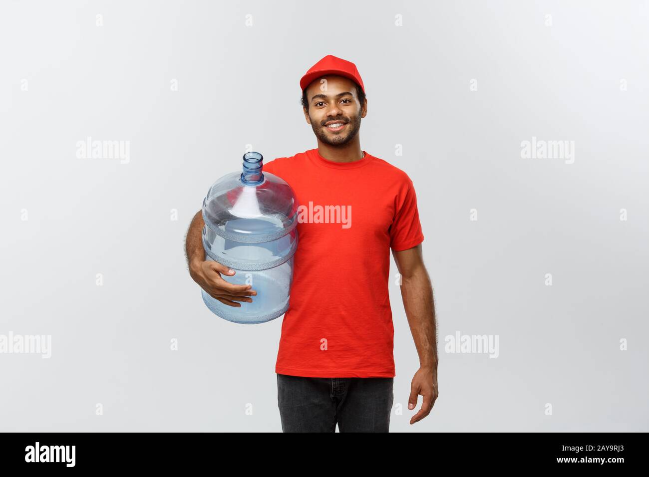 https://c8.alamy.com/comp/2AY9RJ3/delivery-concept-handsome-african-american-delivery-man-holding-water-tank-isolated-on-grey-studio-background-copy-space-2AY9RJ3.jpg