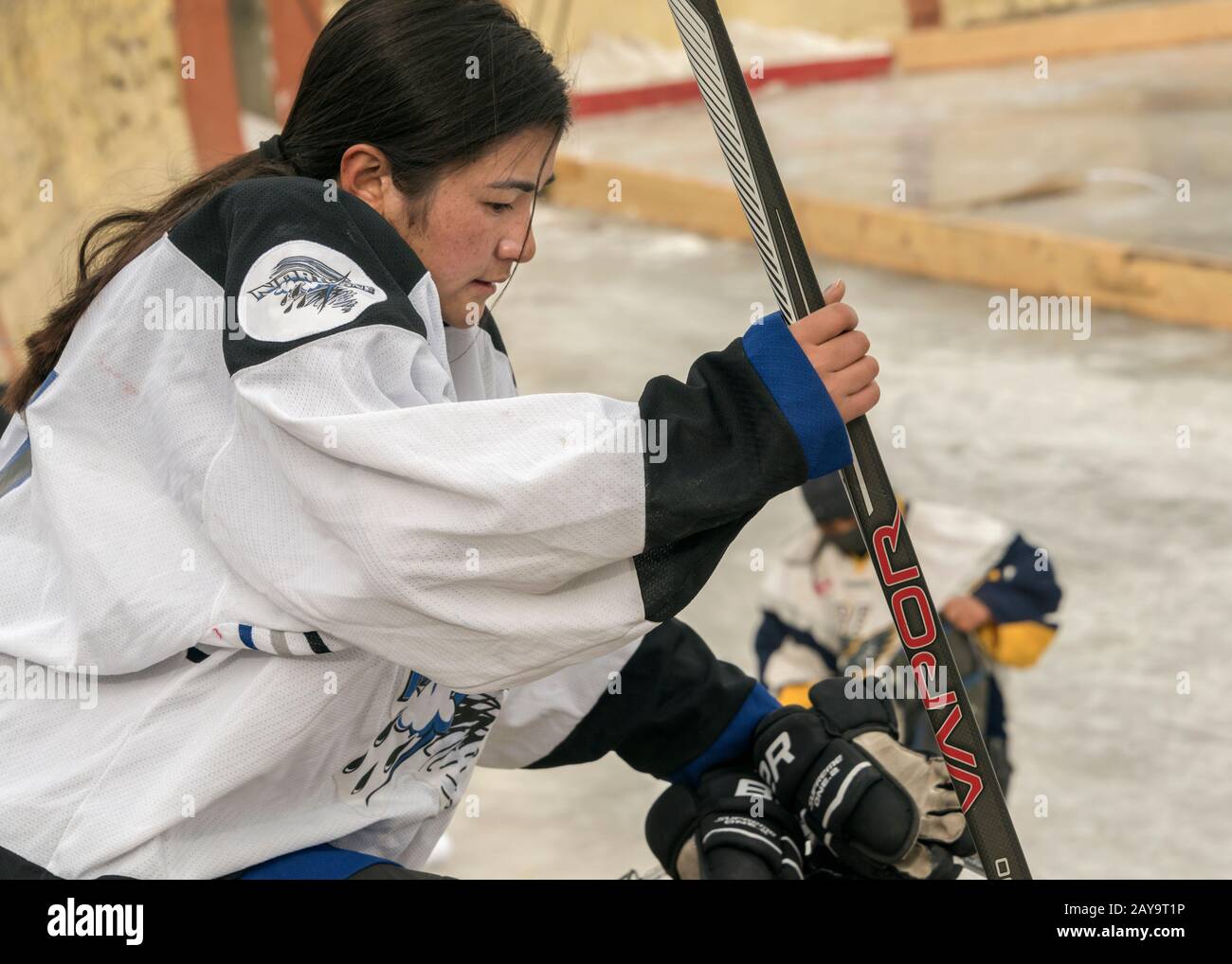 Woman hockey player getting ready for a game, outdoor ice rink, Leh, Ladakh, India Stock Photo