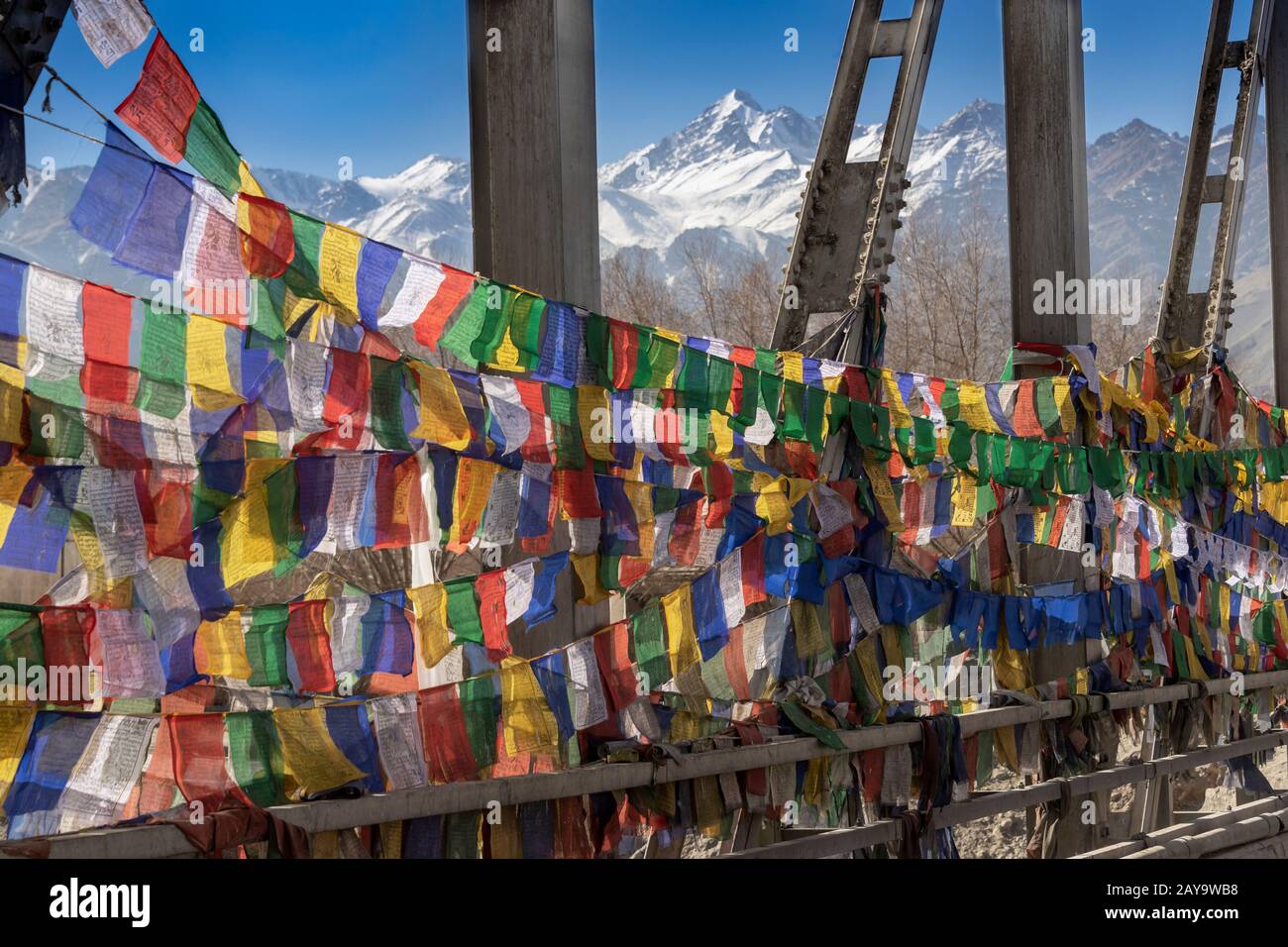Prayer flags on the Chuckhot Rd bridge looking towards the Ladakh Range, Leh, Ladakh, India Stock Photo