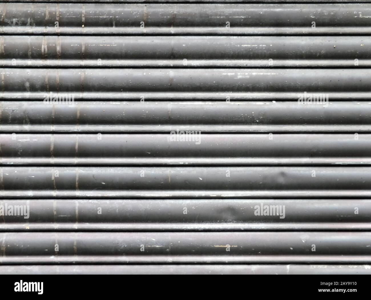 dirty old grey stained horizontal closed steel rolling security shutters Stock Photo