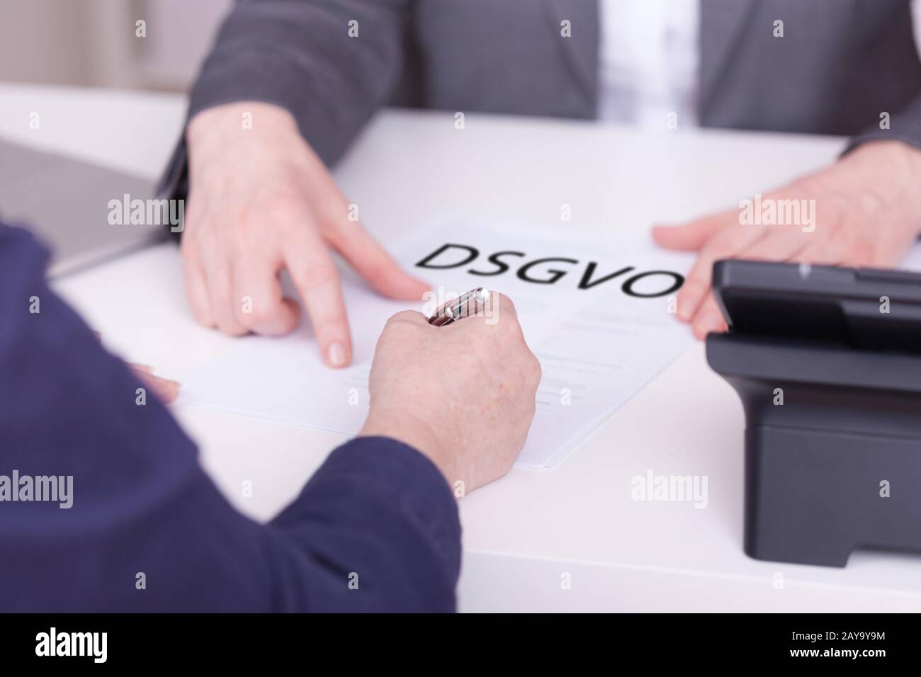 Two women at the office. Concept for signing a contract concerning DSGVO. Stock Photo