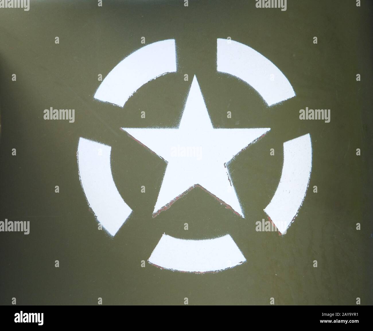 a white US army star in an invasion circle stencilled on an olive green painted military vehicle Stock Photo