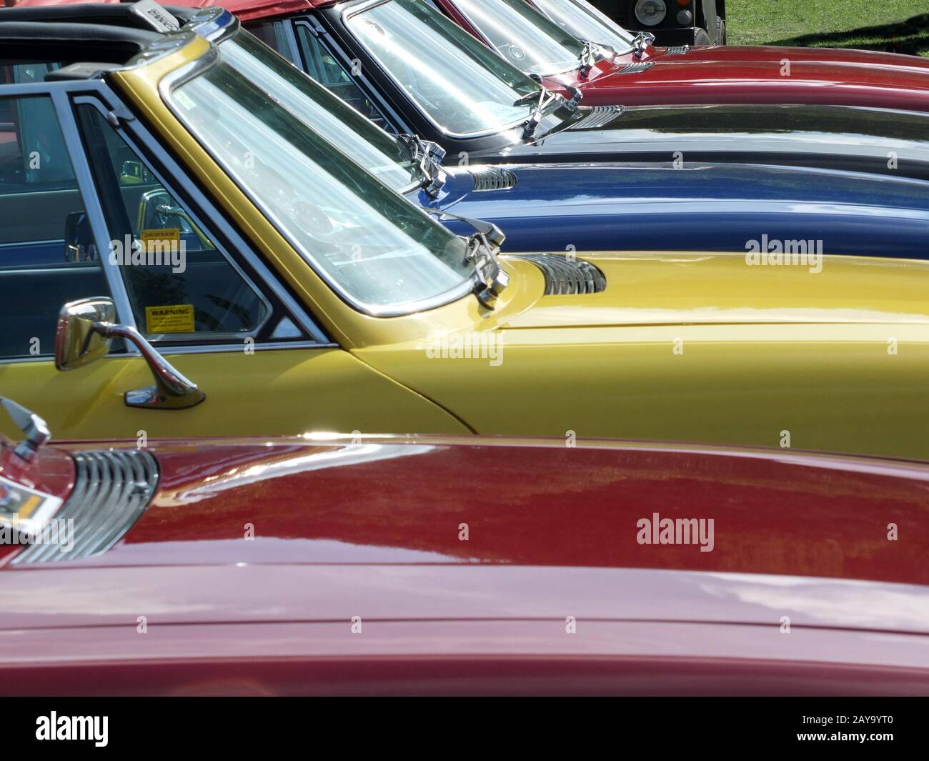 Close up of the bonnets and windscreens of a row of vintage triumph stag sports cars Stock Photo