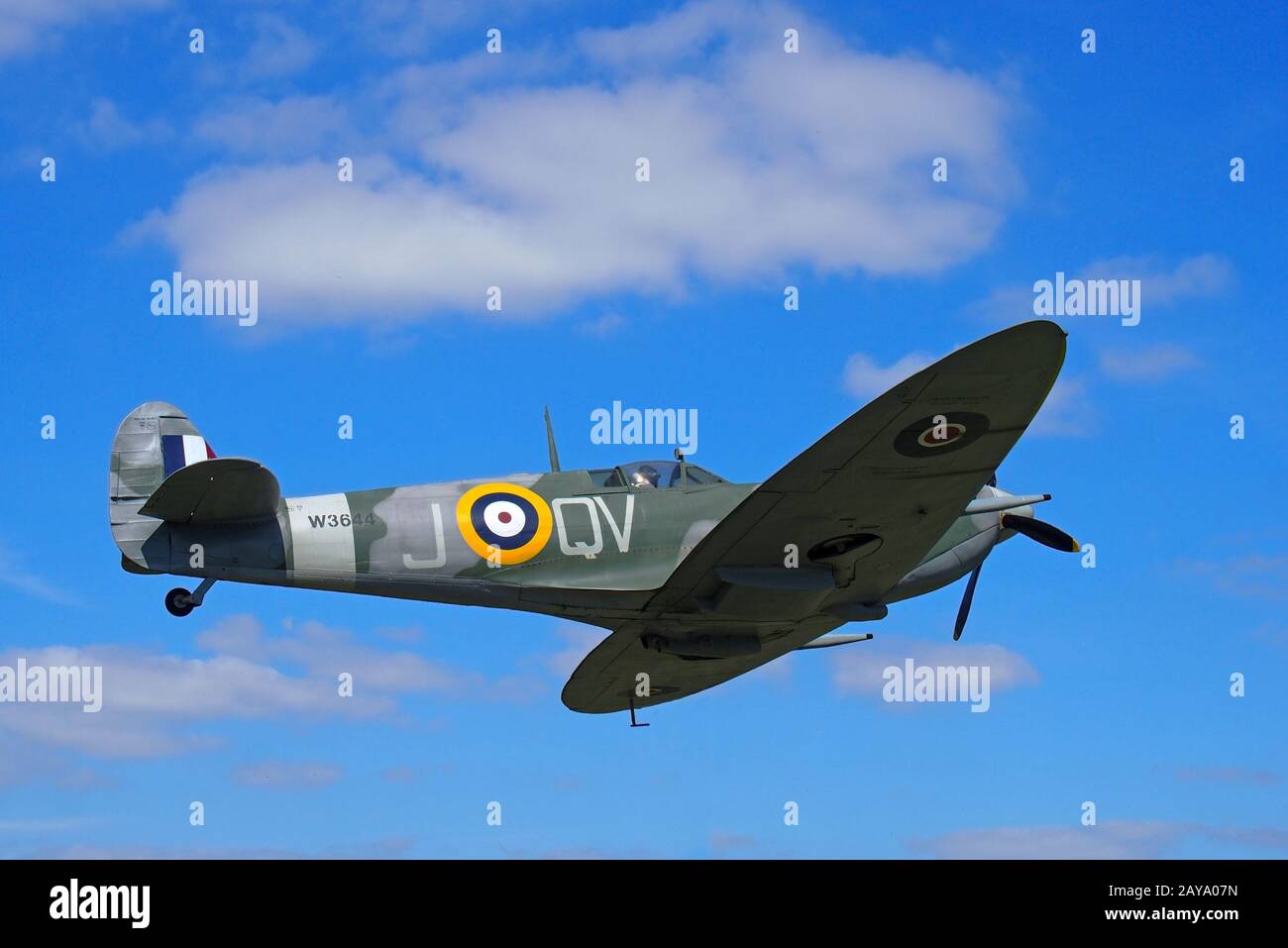 Vintage world war 2 Mark Vb spitfire in flight againt a blue sky with clouds Stock Photo