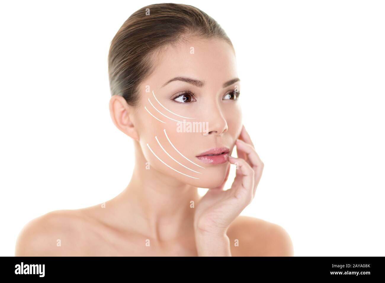 Face lift treatment anti aging skincare beauty woman concept. Skin care Asian model touching face with lifting arrows lines facelift design. Portrait in studio isolated on white background. Stock Photo