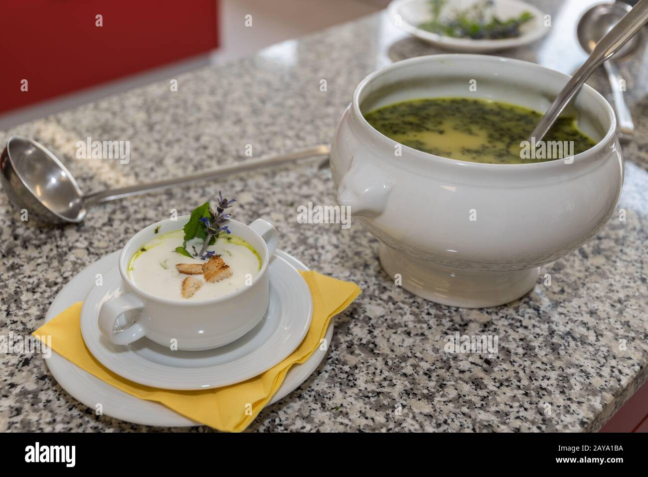 Tureen with ladle and garnished cream soup in soup plate Stock Photo