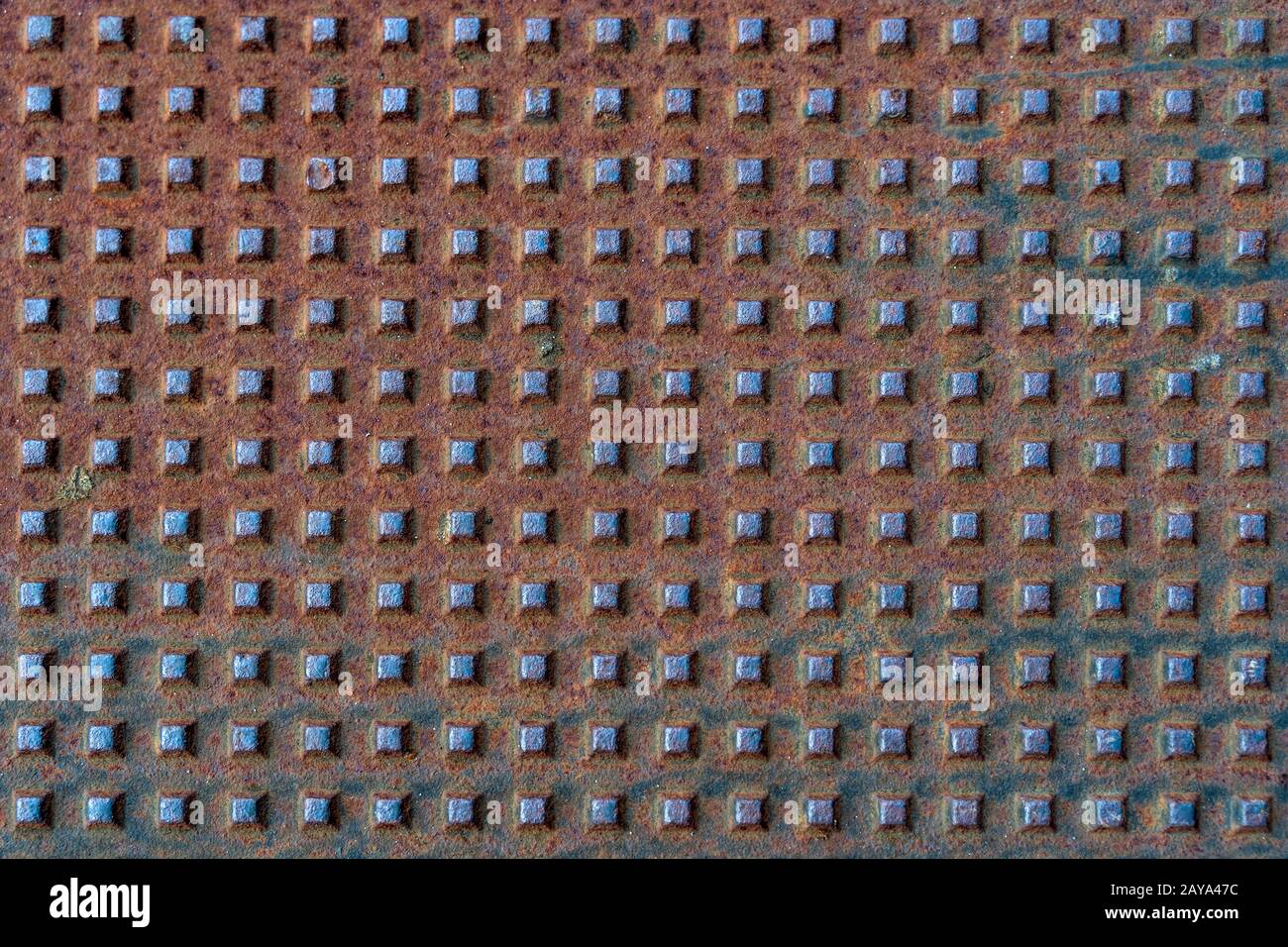 Square shapes on rusted metal surface with patterns and cracks Stock Photo
