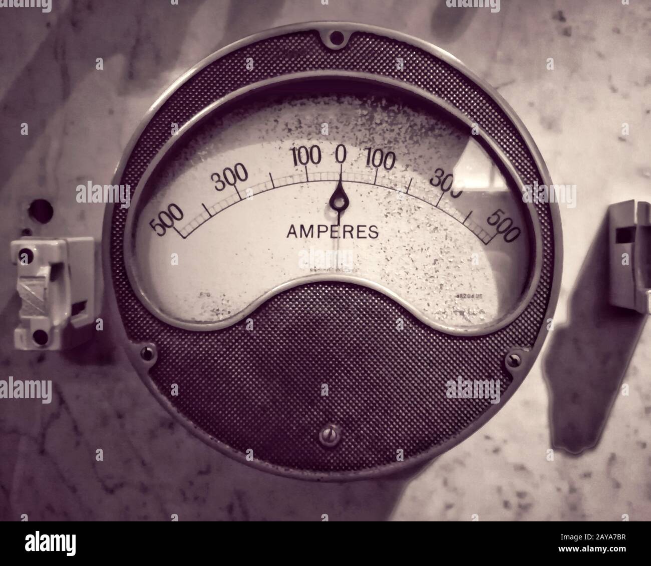 monochrome image of an old round metal industrial ammeter with an analogue dial and scale Stock Photo