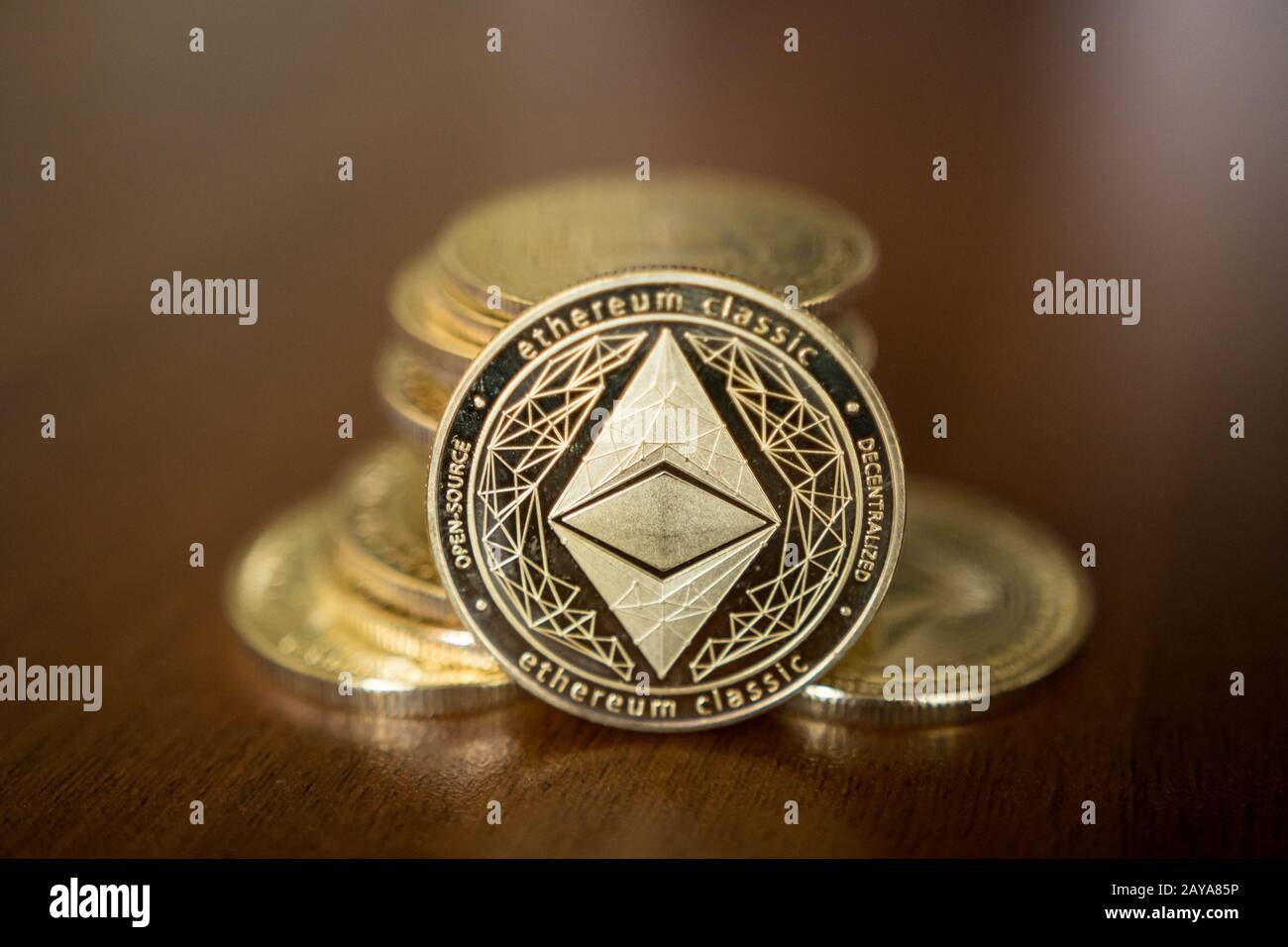 Golden Etherium coin close up. Ether is a cryptocurrency whose blockchain is generated by the Ethereum platform. Stock Photo