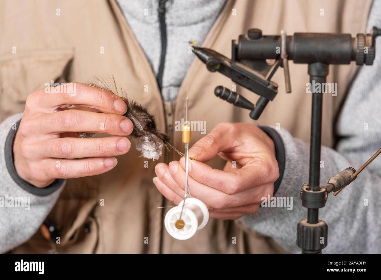 Man making trout flies. Fly tying equipment and material for fly