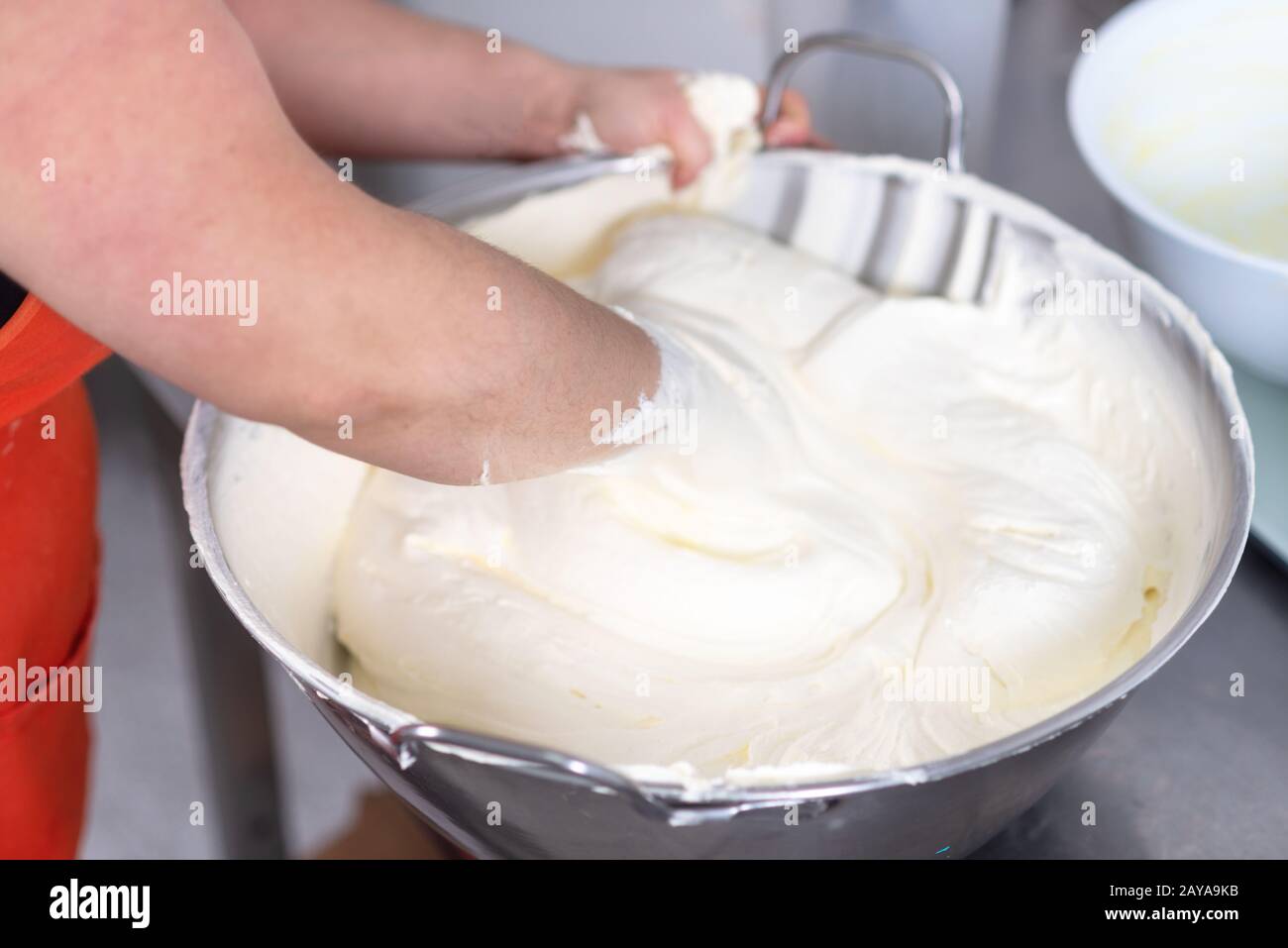 Mixing white egg cream in bowl with hands, baking cake. Stock Photo