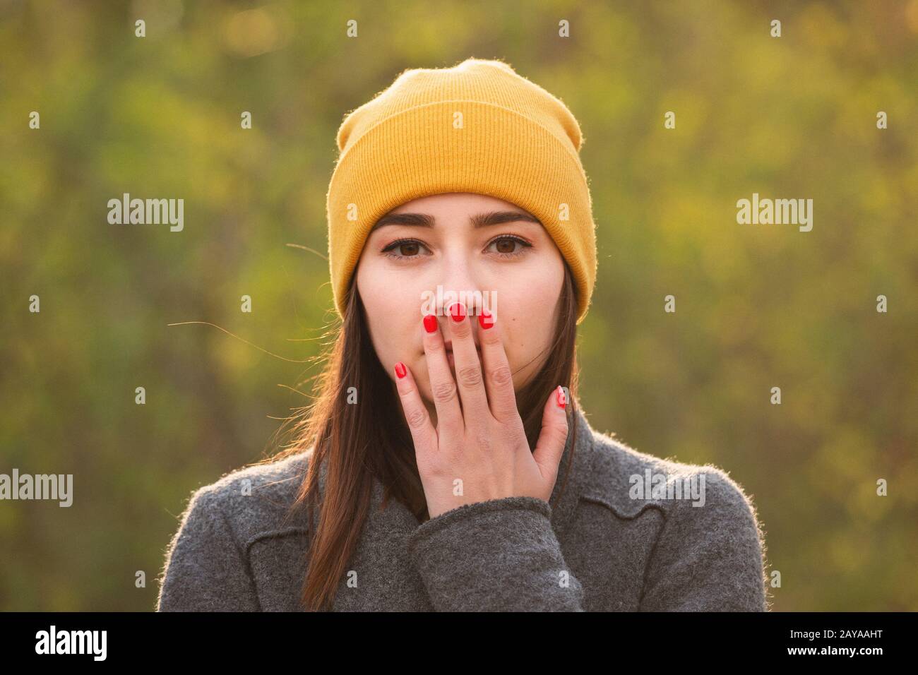 Young woman covering her mouth with her hand. Stock Photo