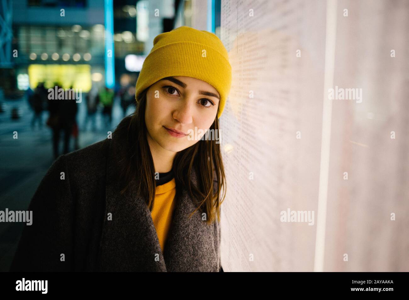 Young woman leans at a illuminated departure plan. Travel,lifestyle and youth concept. Stock Photo