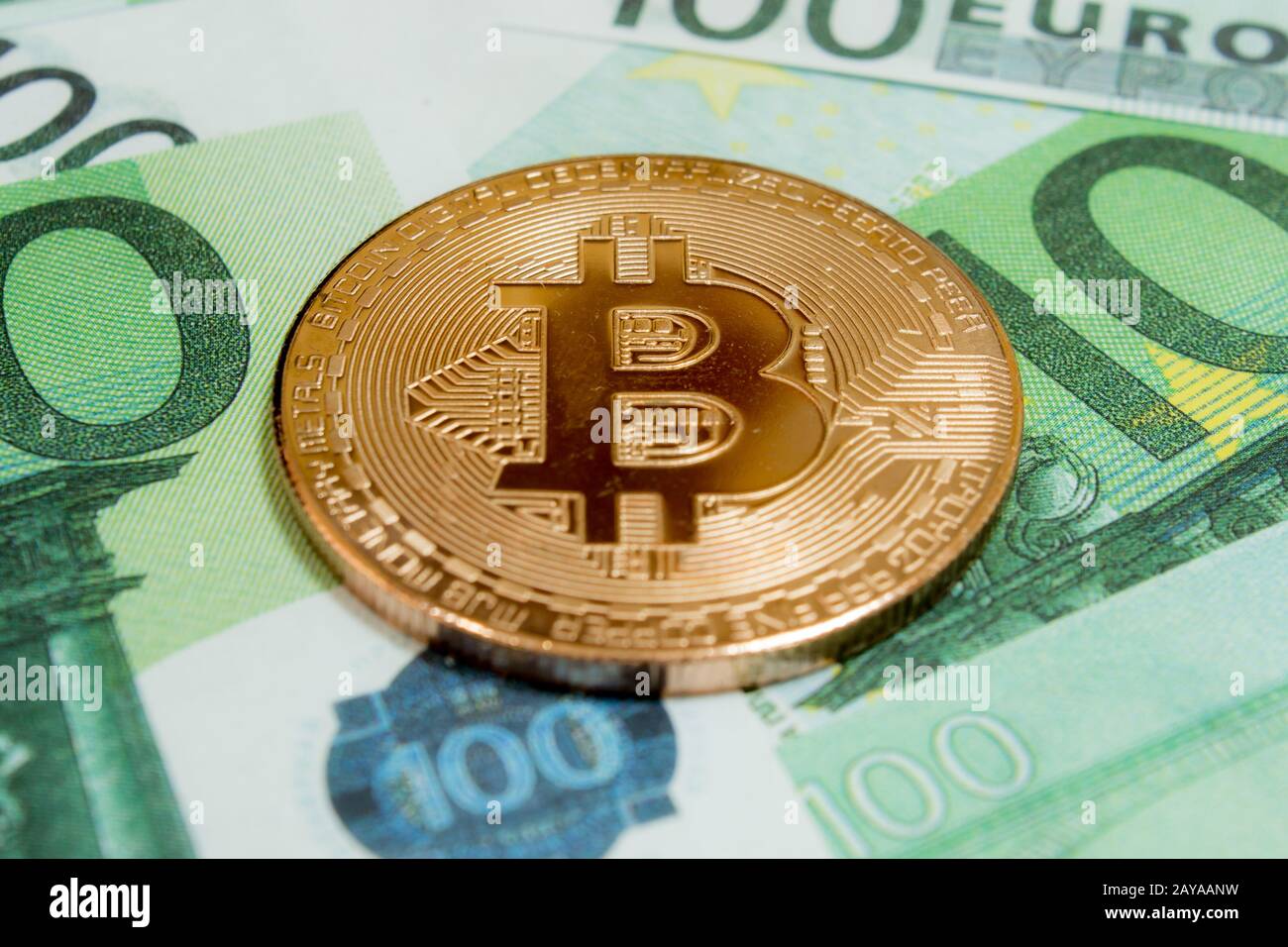 Close-up of Bitcoin coins on 100 Euro banknotes. Crypto currency BTC. Stock Photo
