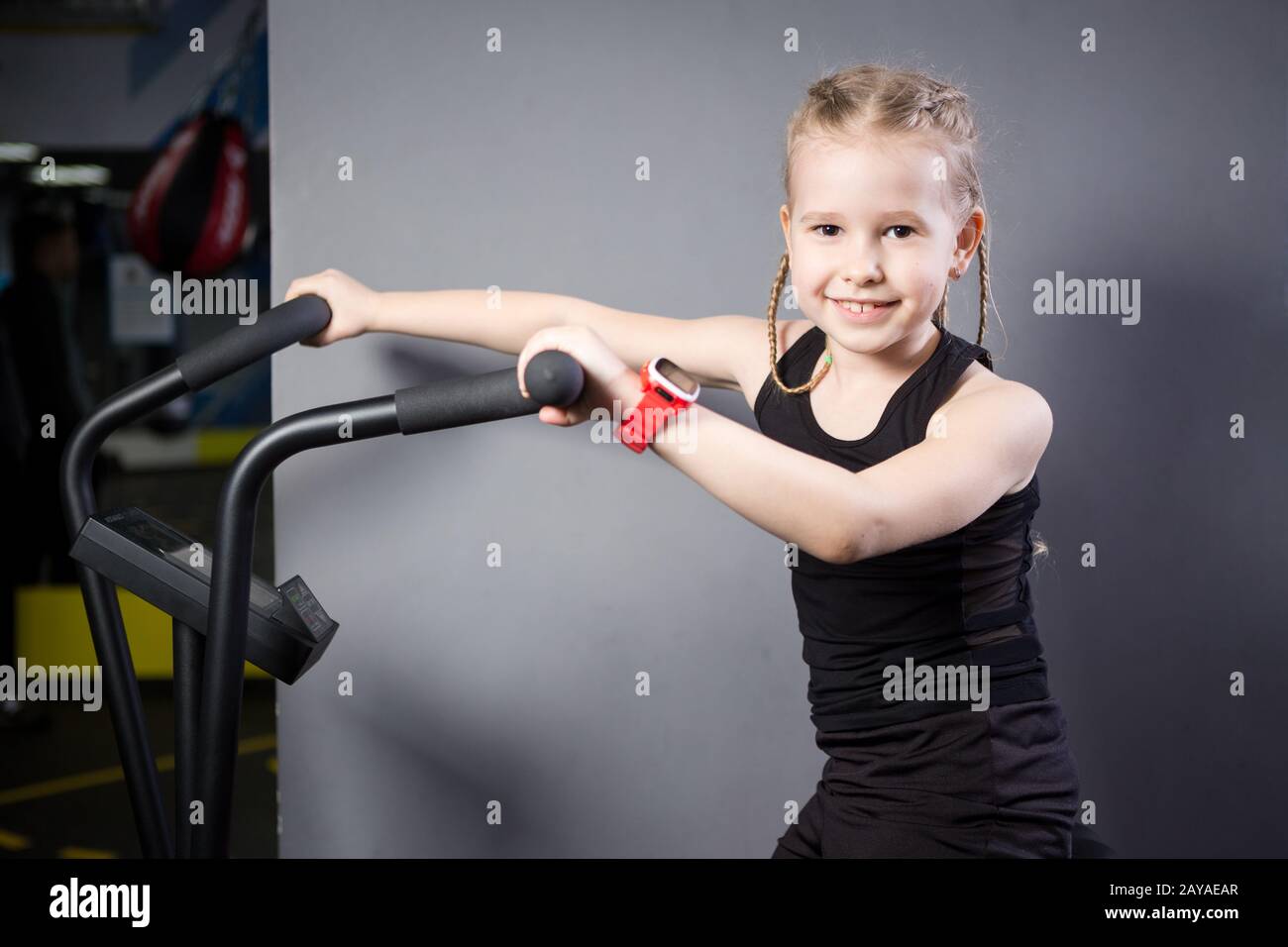 Small attractive caucasian child using exercise bike in the gym. Fitness. A little athlete using an air bike for a cardio workou Stock Photo Alamy