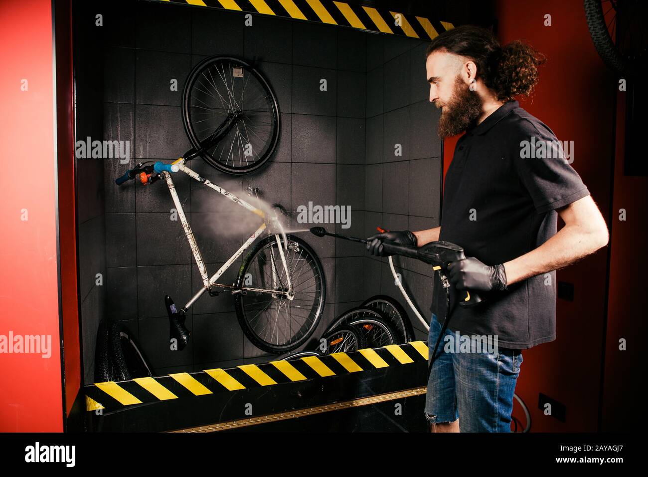 Cleaning a very muddy bike frame hires stock photography and images