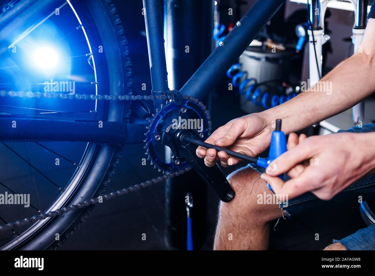 Closeup of man's hands bicycle mechanics in the shop uses instment to