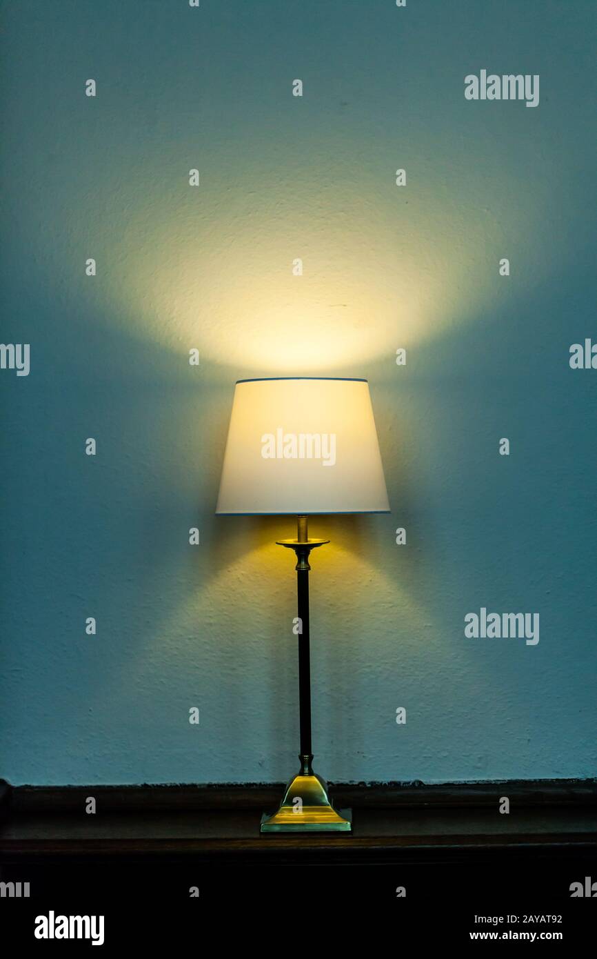 Metal base table lamp lighted lying wooden furniture. Luminous stand chandelier classic style