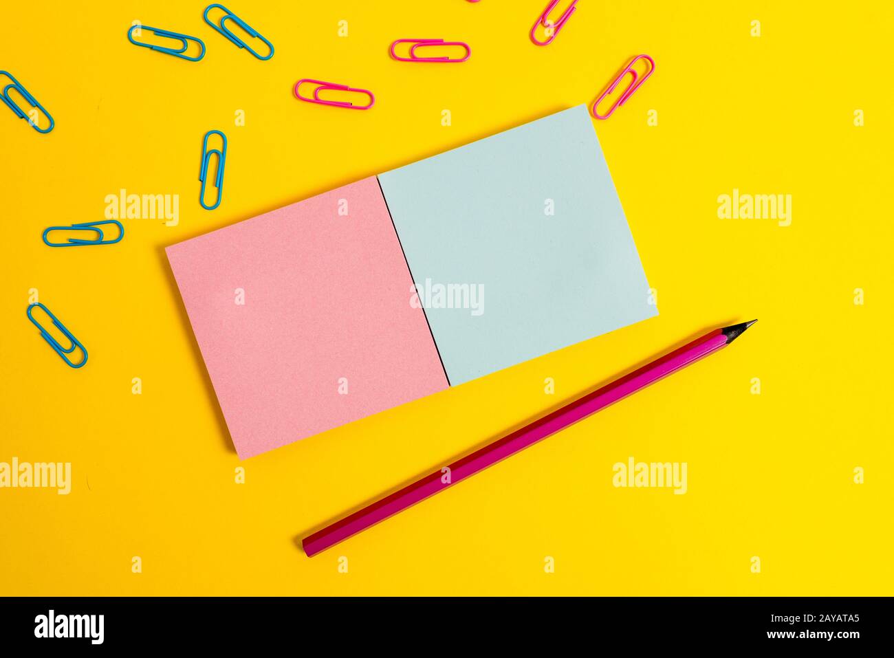Front view colored blank notepads clips pencil plain color background. Empty text important future events. What to do home schoo Stock Photo
