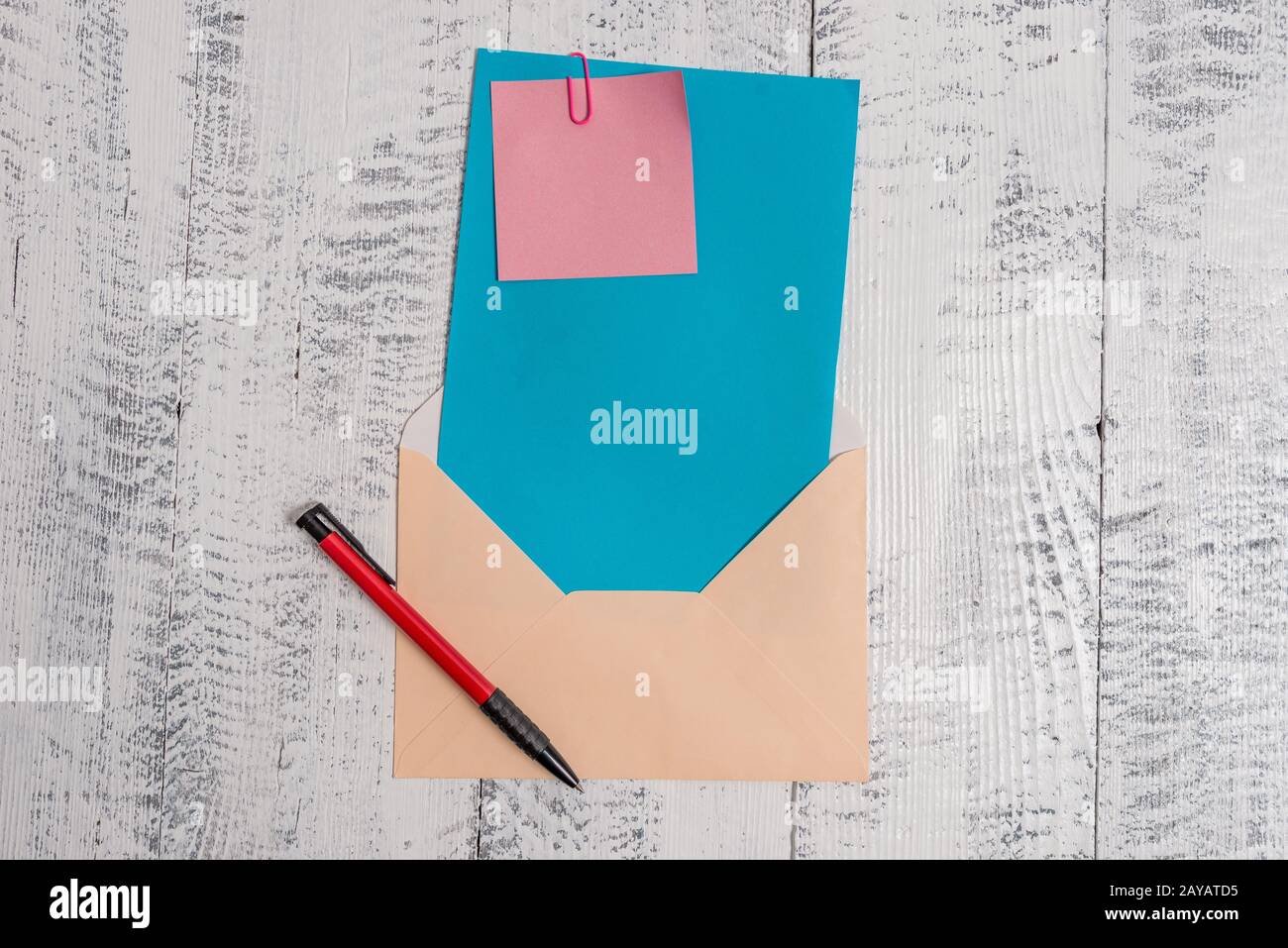 Front view open colored rectangular envelope blank sheet paper sticky note ballpoint lying retro vintage rustic old lumber timbe Stock Photo