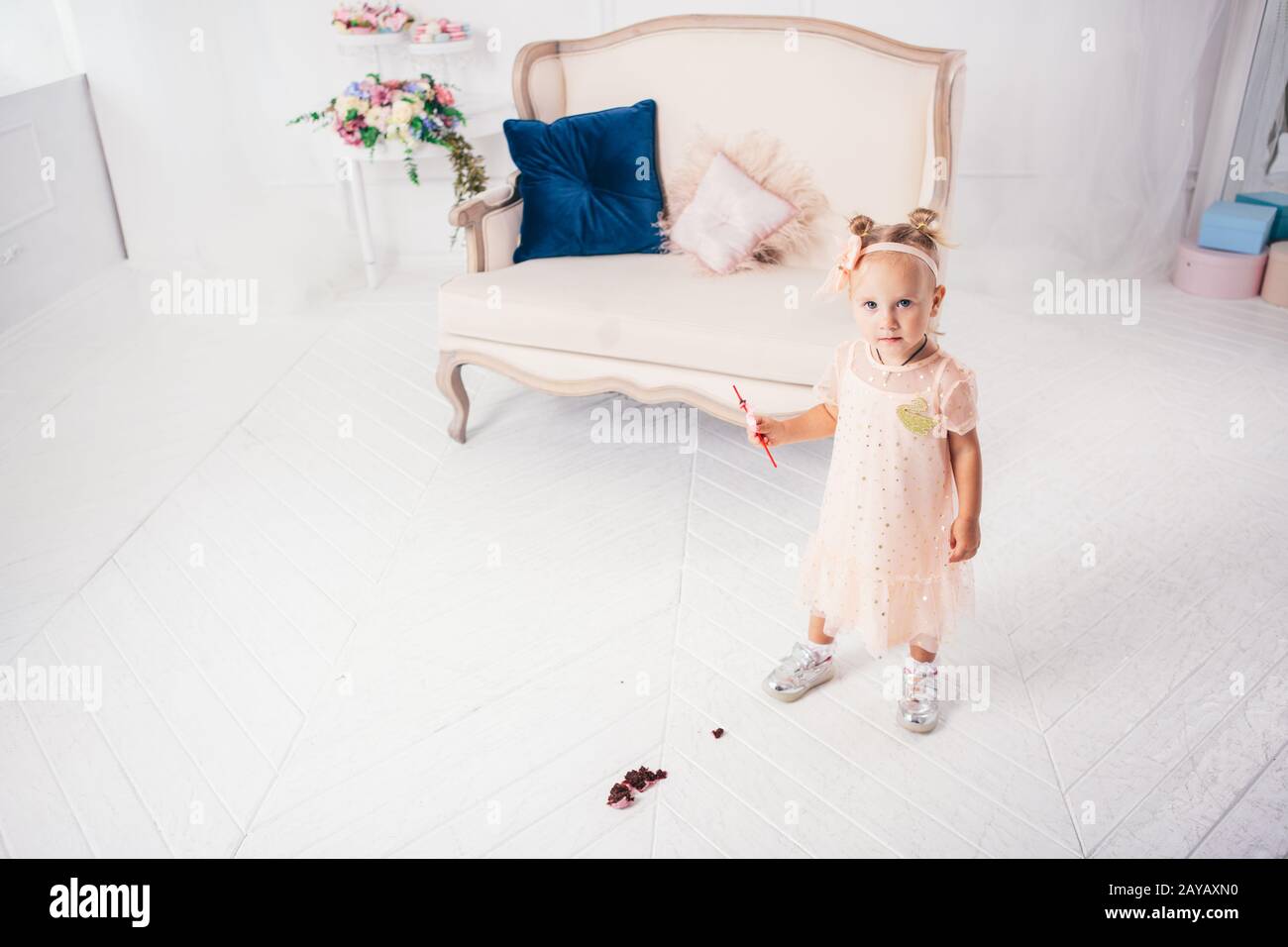 Little funny caucasian child girl dropped on the floor sweetness dessert cake and mess. Kindergarten and birthday party spoiled, Stock Photo
