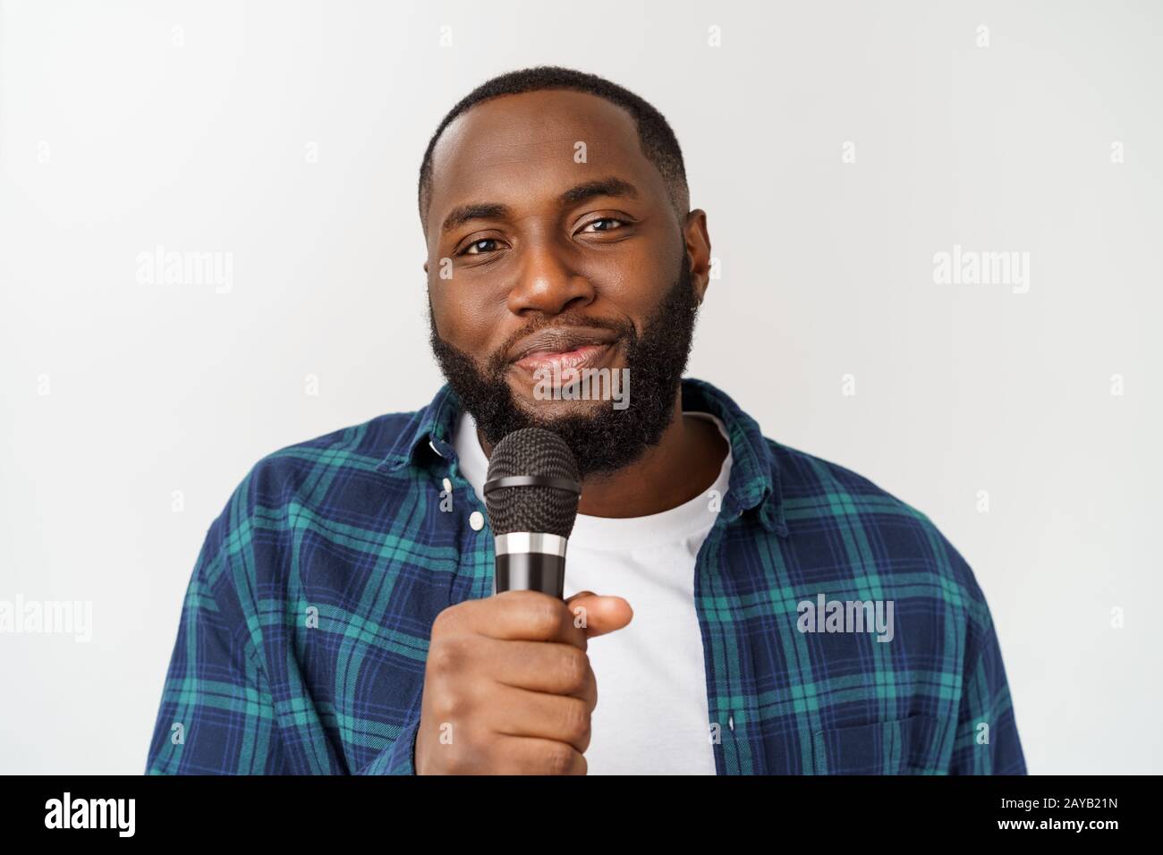 young handsome african american boy singing emotional with microphone isolated on white background. Stock Photo