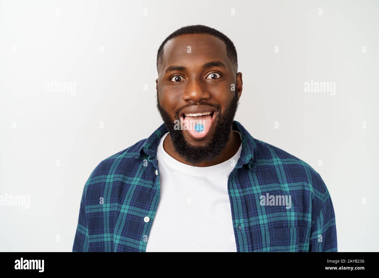 Studio shot of young African American man with candy in mouth against gray background Stock Photo