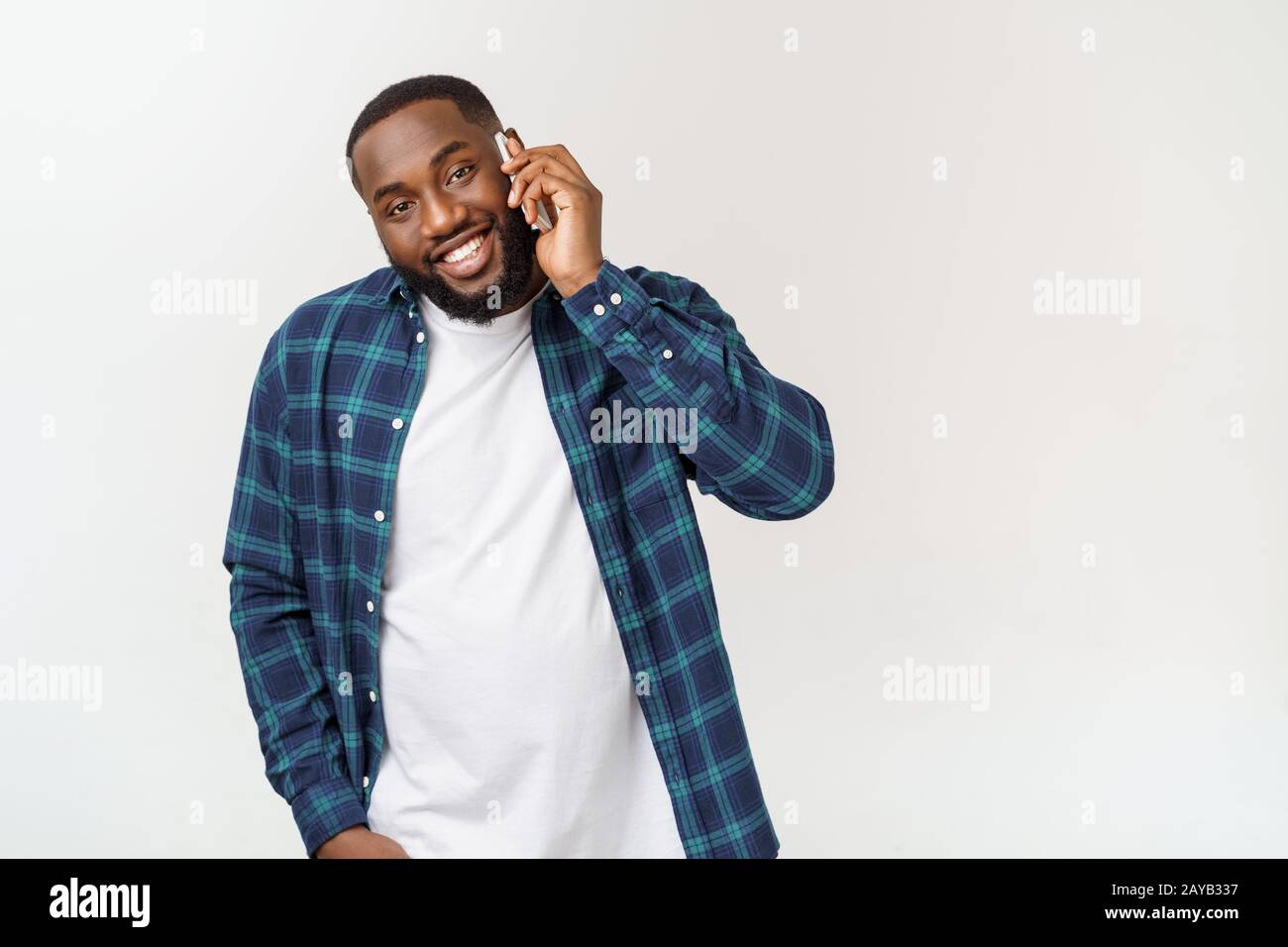 Young black man smiling and talking on mobile phone. Stock Photo