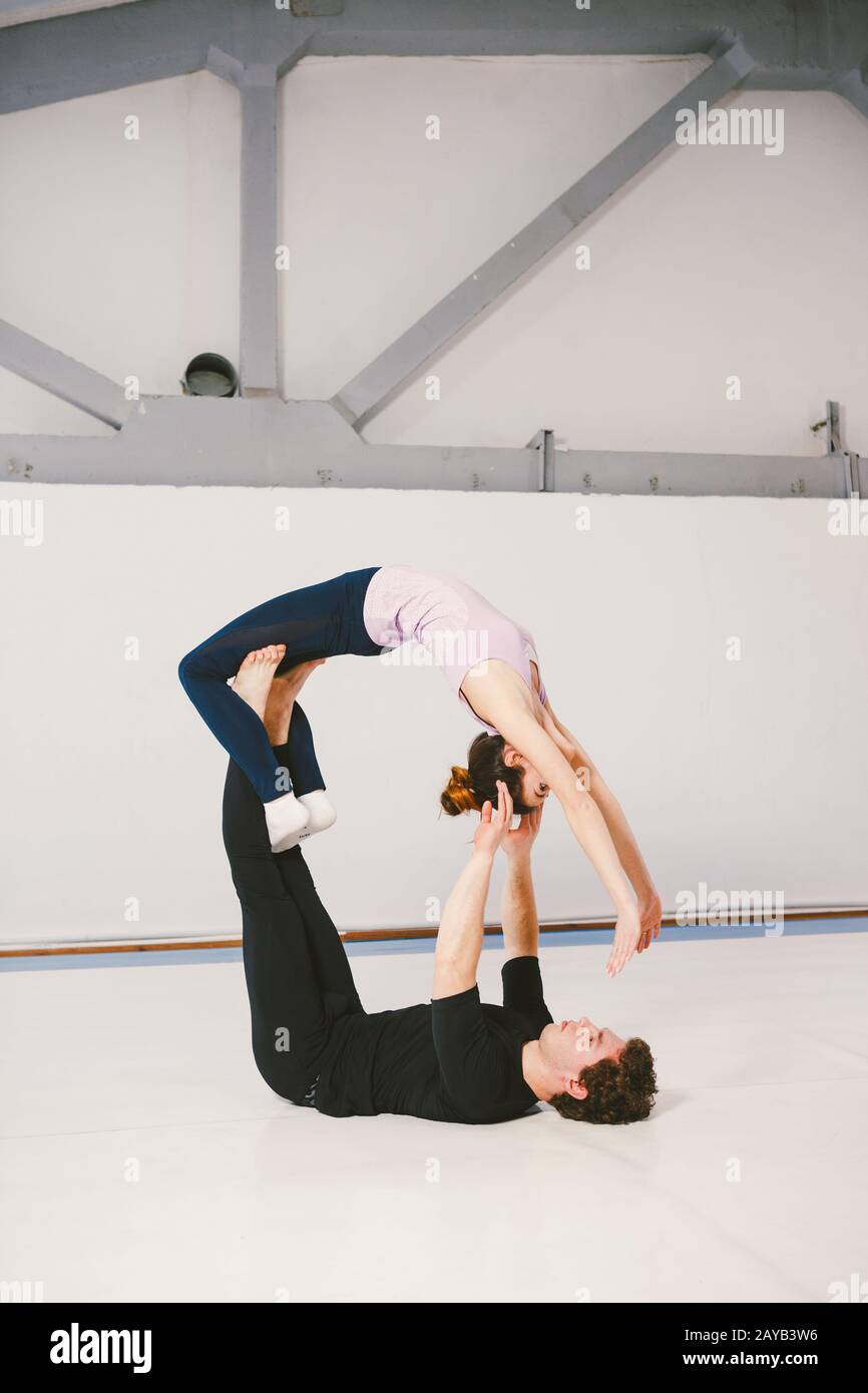 Two athletes performing duo acroyoga poses Stock Photo by Photology75