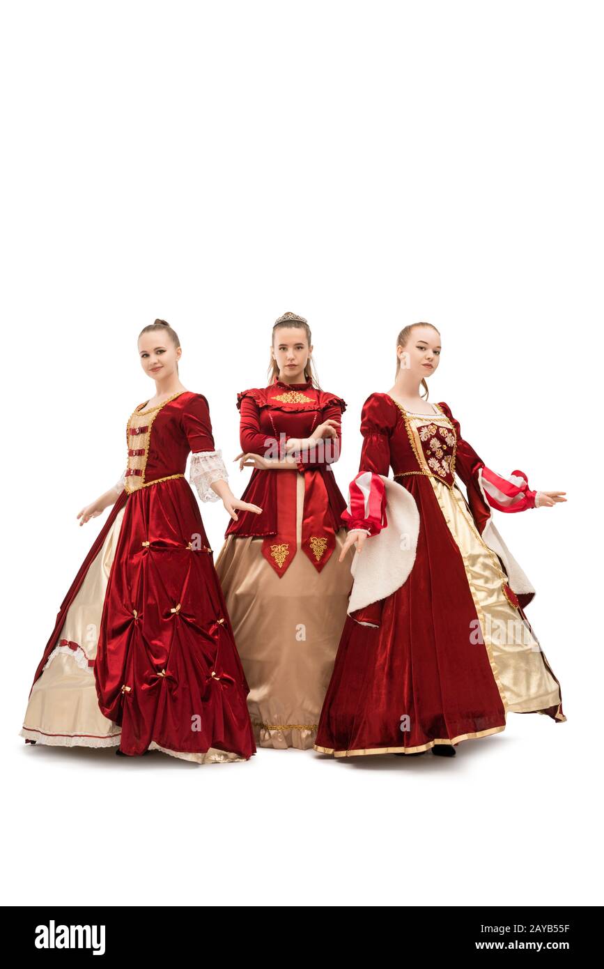 Three girls in gorgeous queen red dresses Stock Photo