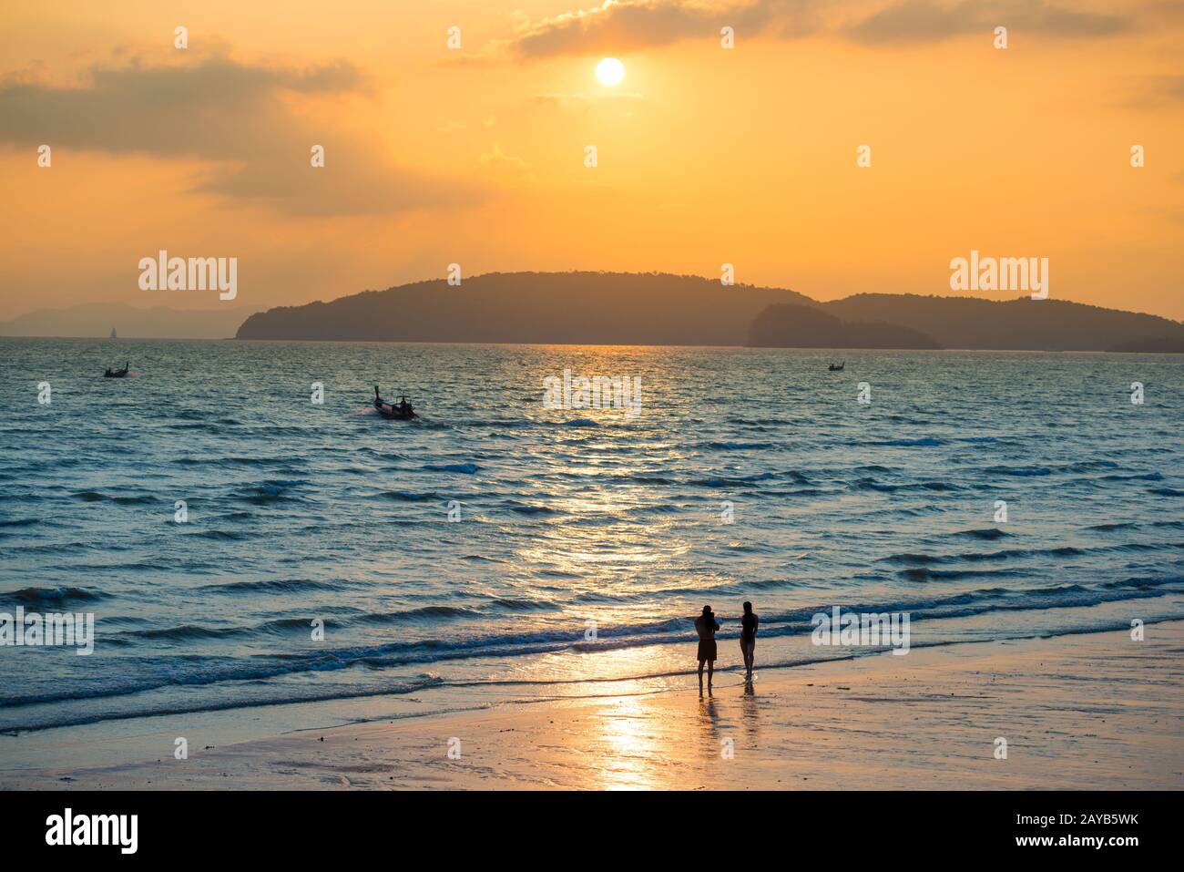 Silhouettes of people on beach at sunset Stock Photo - Alamy