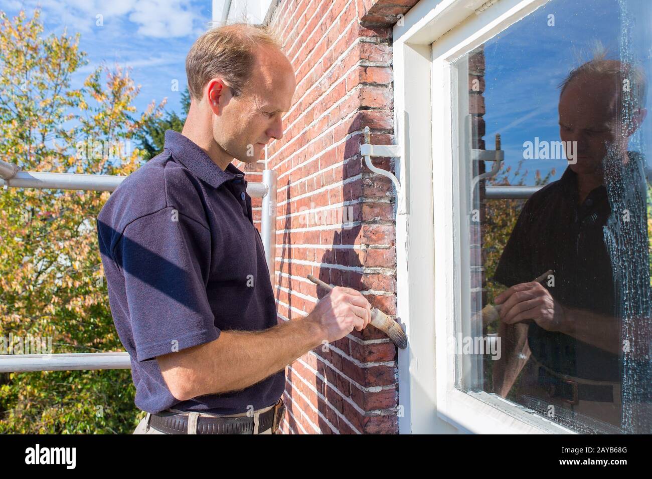 Dutch painter paints window frame with brush Stock Photo Alamy