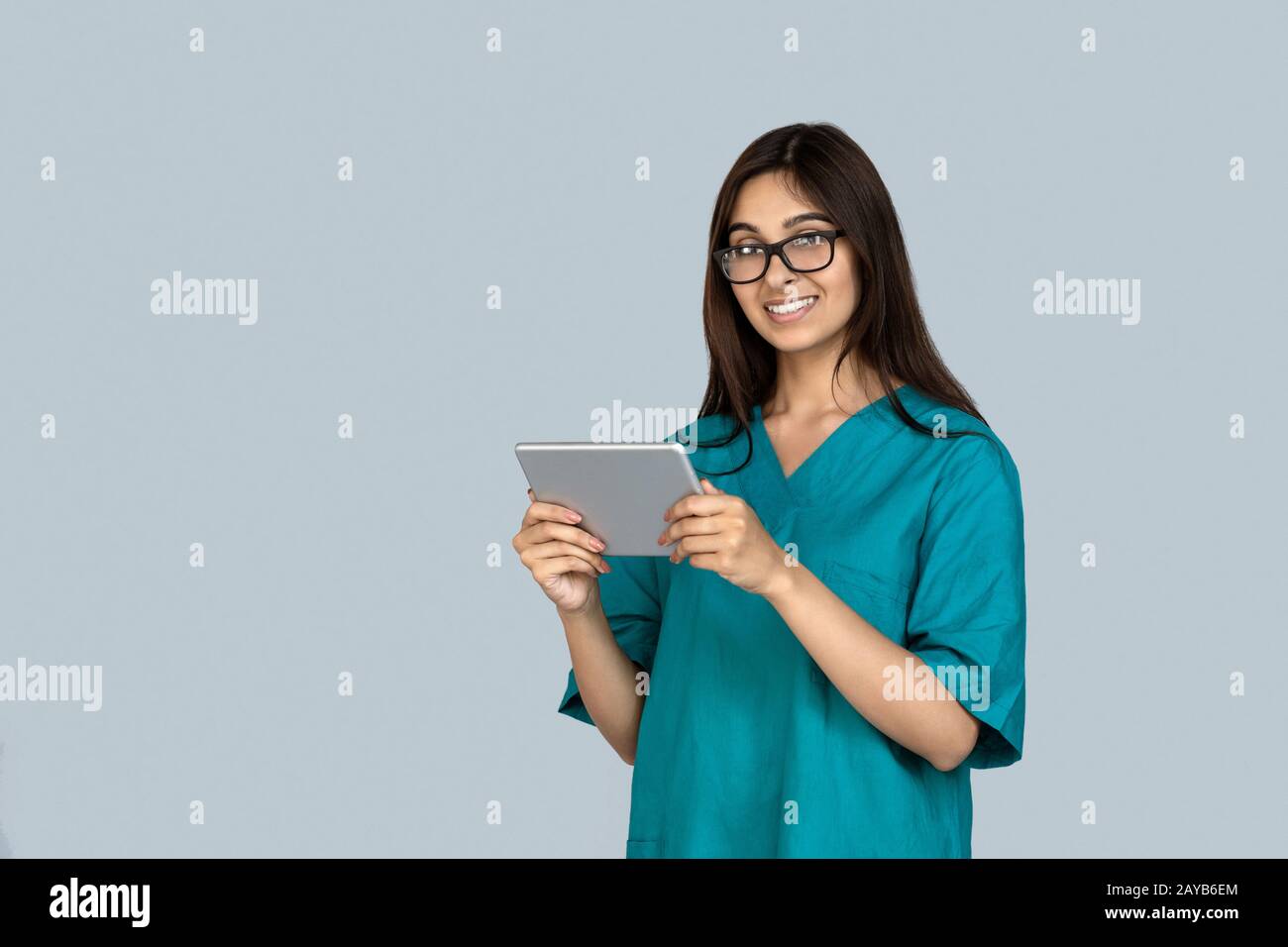 Young adult indian woman in doctor uniform holding tablet computer Stock Photo