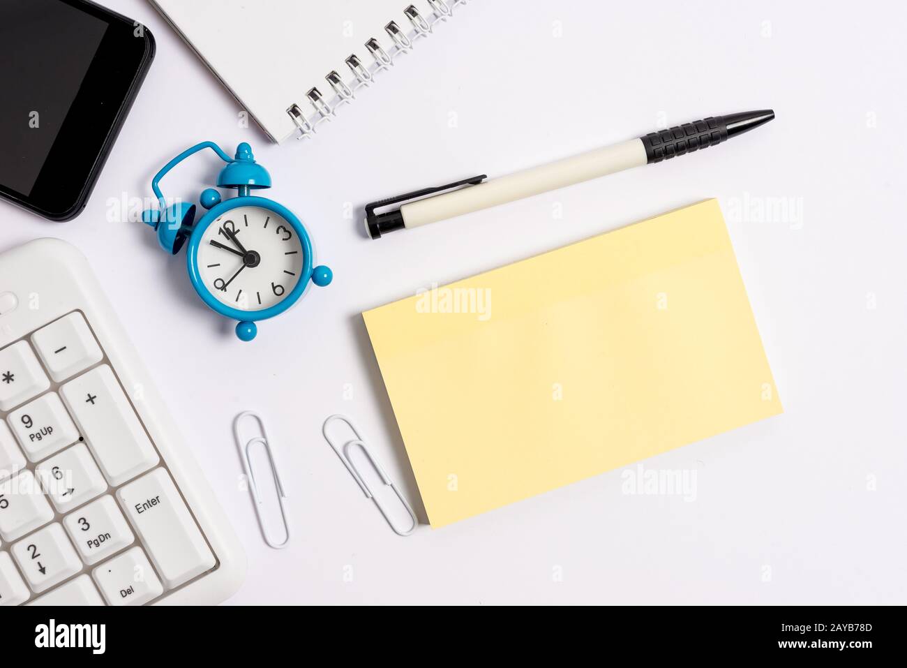 Flat lay above computer mobile phone pencil clock and copy space note paper. Business concept with phone and blank paper for wri Stock Photo