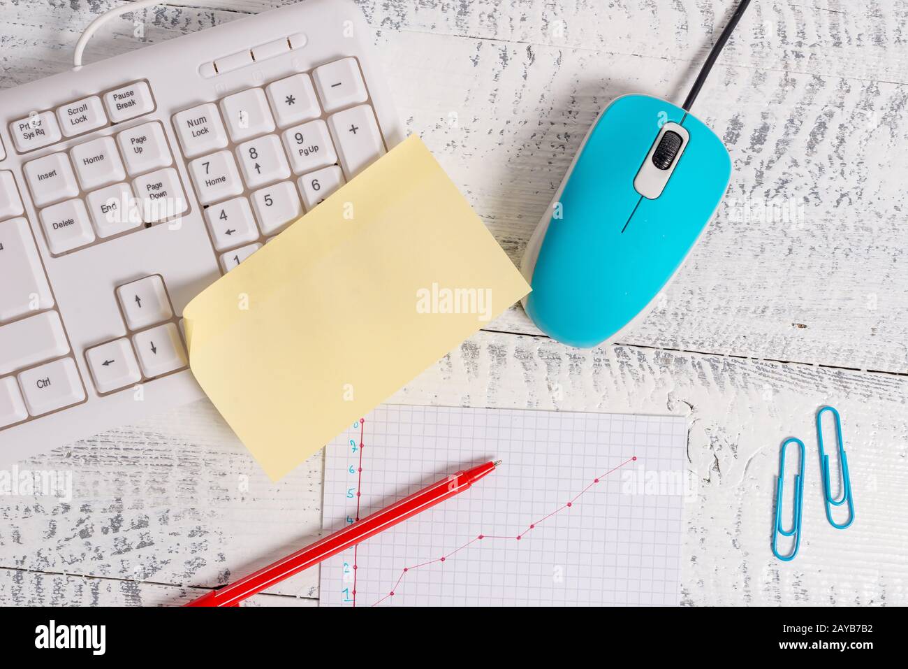 Writing equipments and computer tools plus graphic picture placed on a wooden backdrop. Stationary, mouse, note paper near keybo Stock Photo