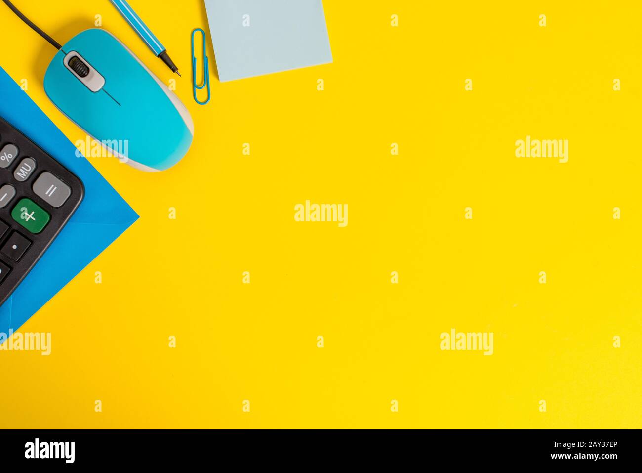 Front view closed envelope clip binder pencil marker sticky note calculator computer wire mouse gadget colored background Empty Stock Photo