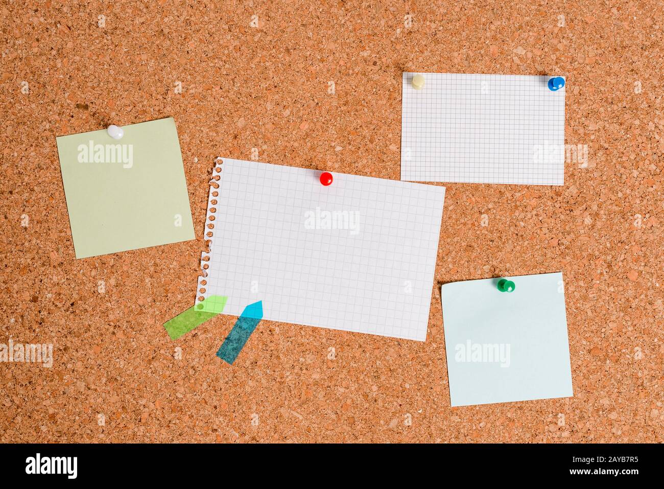 Corkboard with different color and size papers fixed by a pin ...