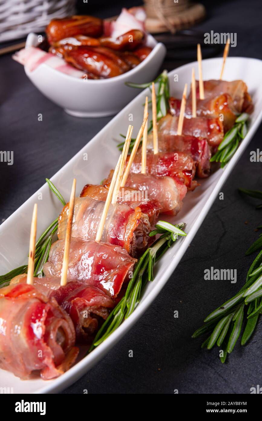 dates wrapped in bacon and delicious tapas Stock Photo Alamy