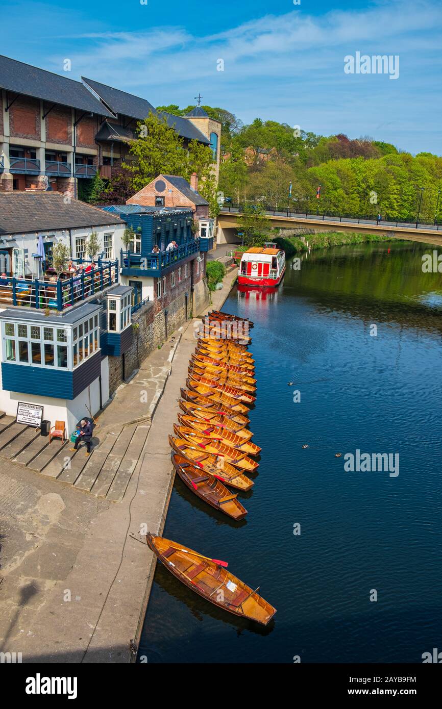 Line of moored rowing boats on the banks of River Wear near a boat club in Durham, United Kingdom on a beautiful spring afternoo Stock Photo