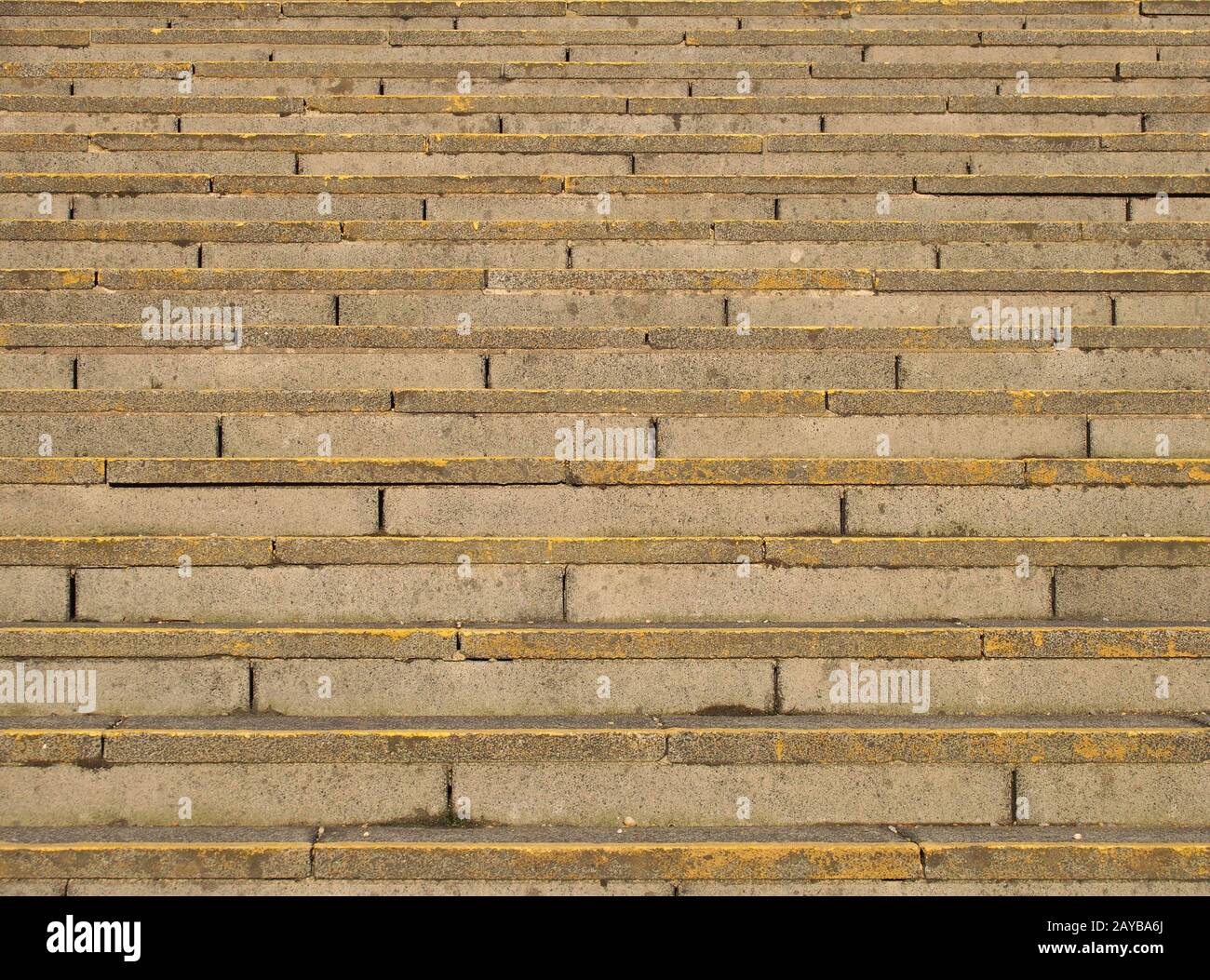 full frame image of old rough concrete stairs with rows of steps in perspective and traces of yellow paint Stock Photo