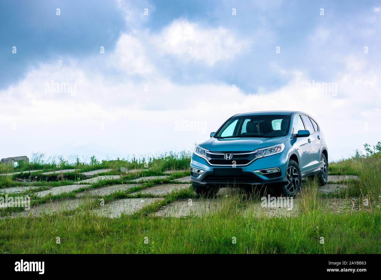 mnt. runa, ukraine - JUN 22, 2019: blue suv on a paved meadow. popular AWD vehicle in nature scenery. stormy weather with cloudy sky. take your family Stock Photo
