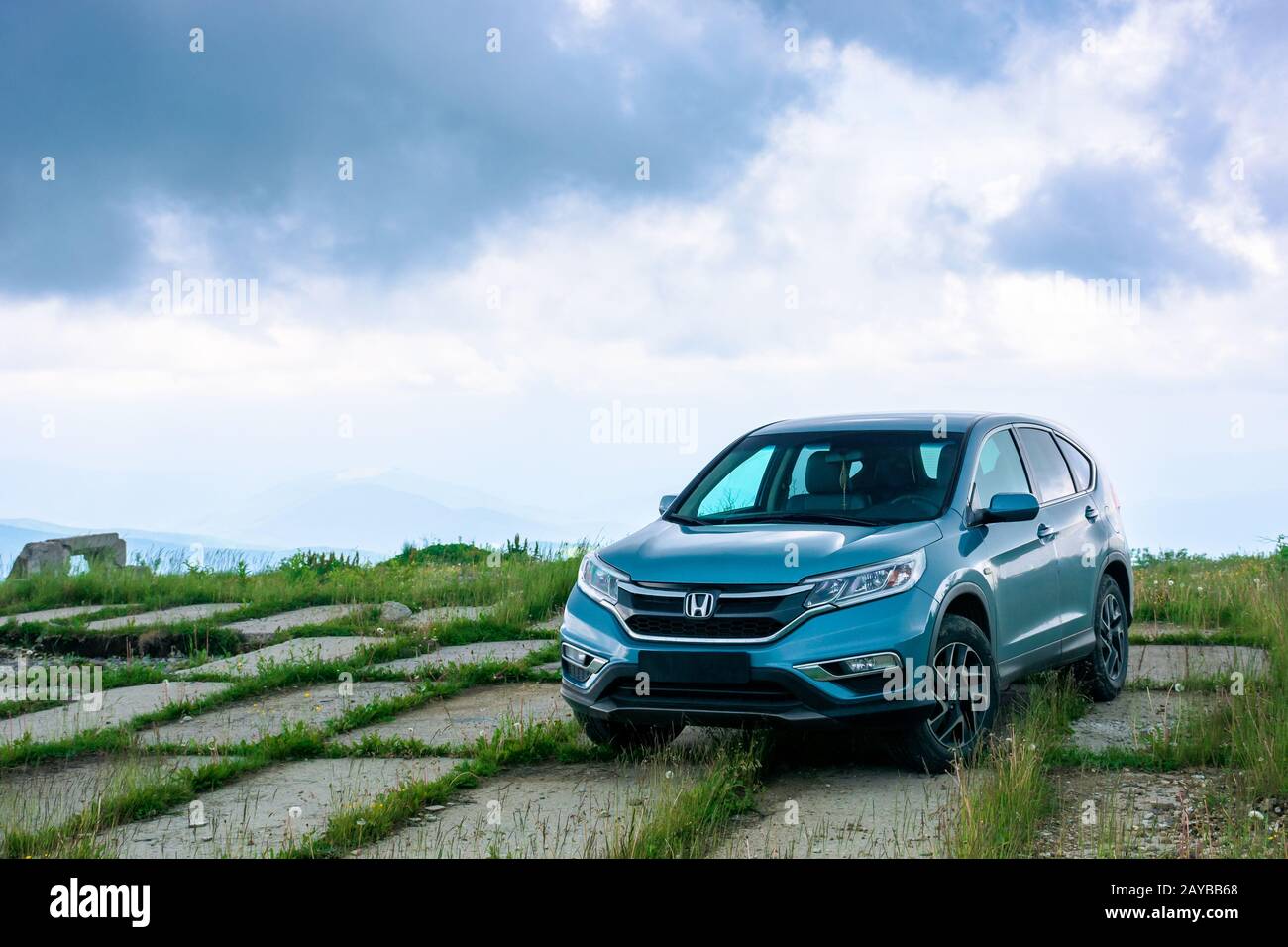 mnt. runa, ukraine - JUN 22, 2019: blue suv on a paved meadow. popular AWD vehicle in nature scenery. stormy weather with cloudy sky. take your family Stock Photo