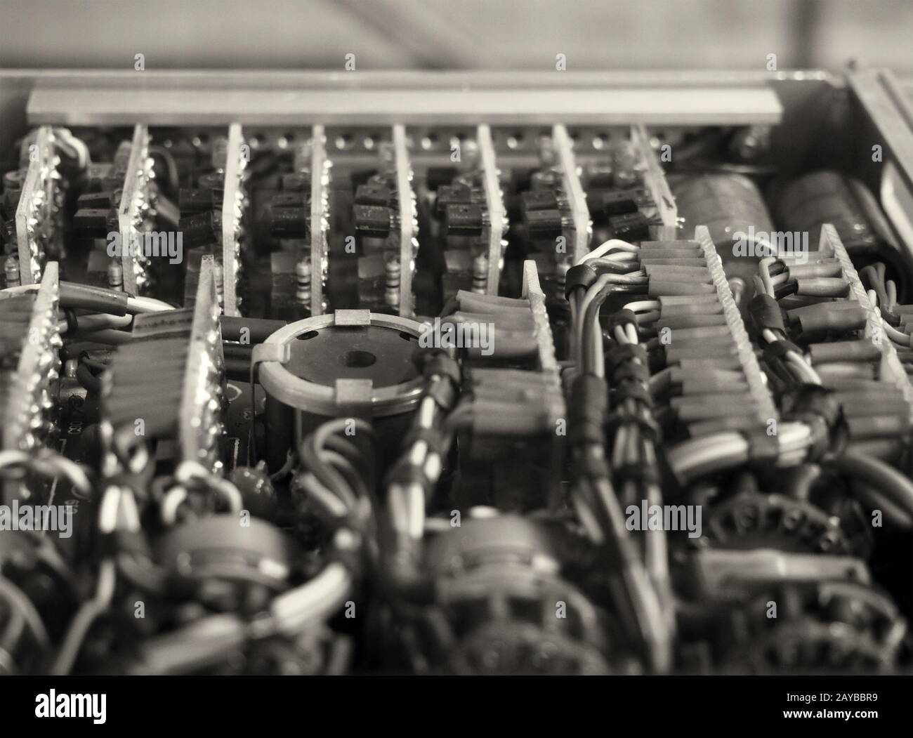 monochrome selective focus image of complex colored wiring and connectors joining circuit boards with electrical components Stock Photo