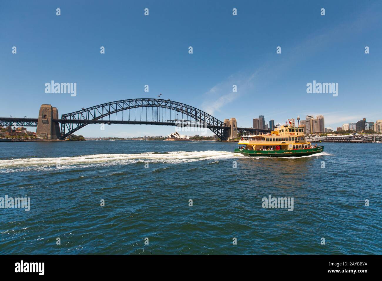 A Sydney ferry crusies past the Sydney Harbour Bridge. Stock Photo