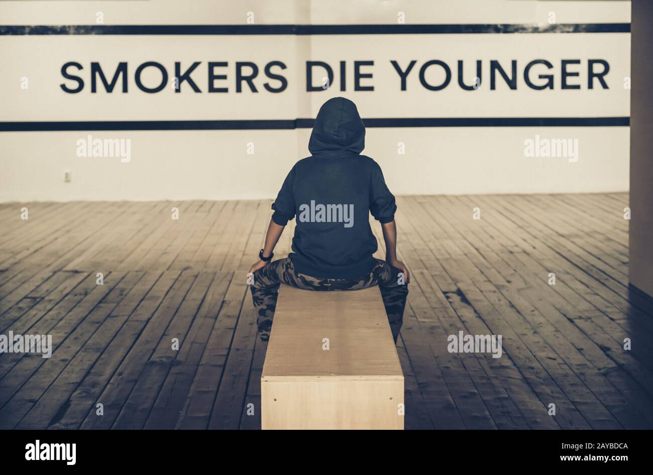 Teenager smoking and message on wall - Smokers die younger. No smoking  concept Stock Photo - Alamy