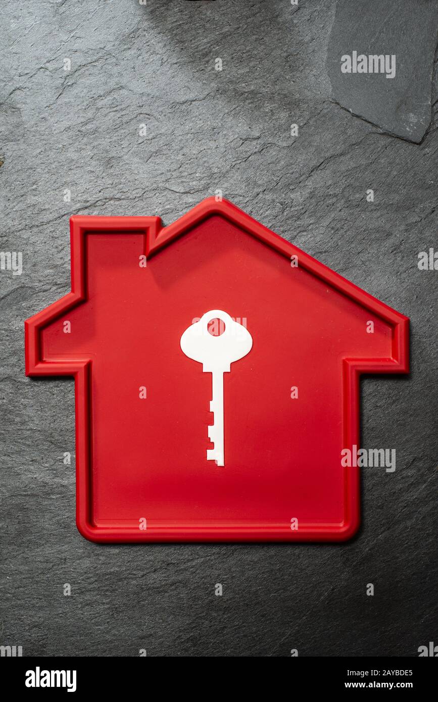 Red colour house shape and white key. Housing and construction concept