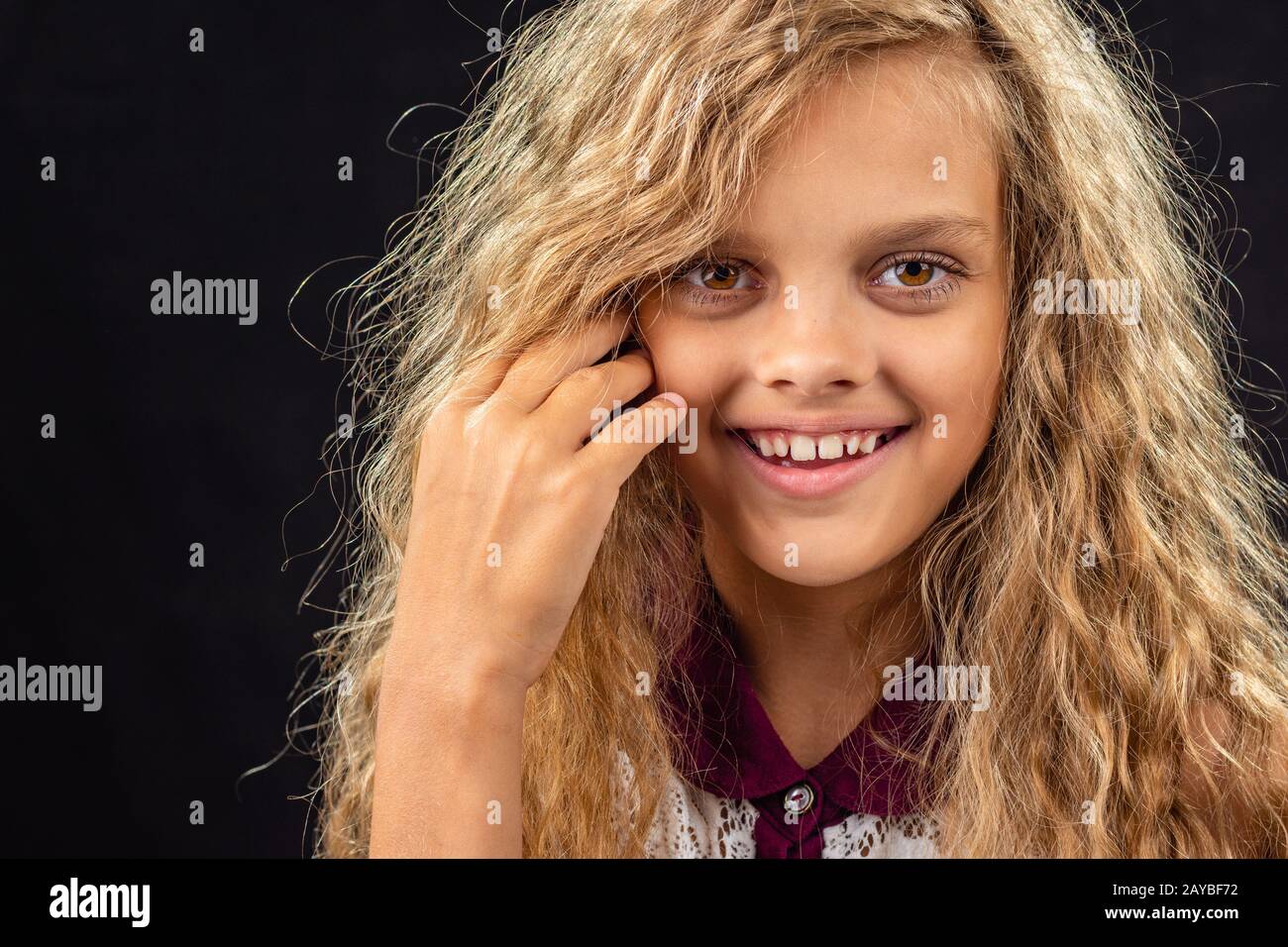 Portrait of a ten year old girl smiling widely with curly blond hair