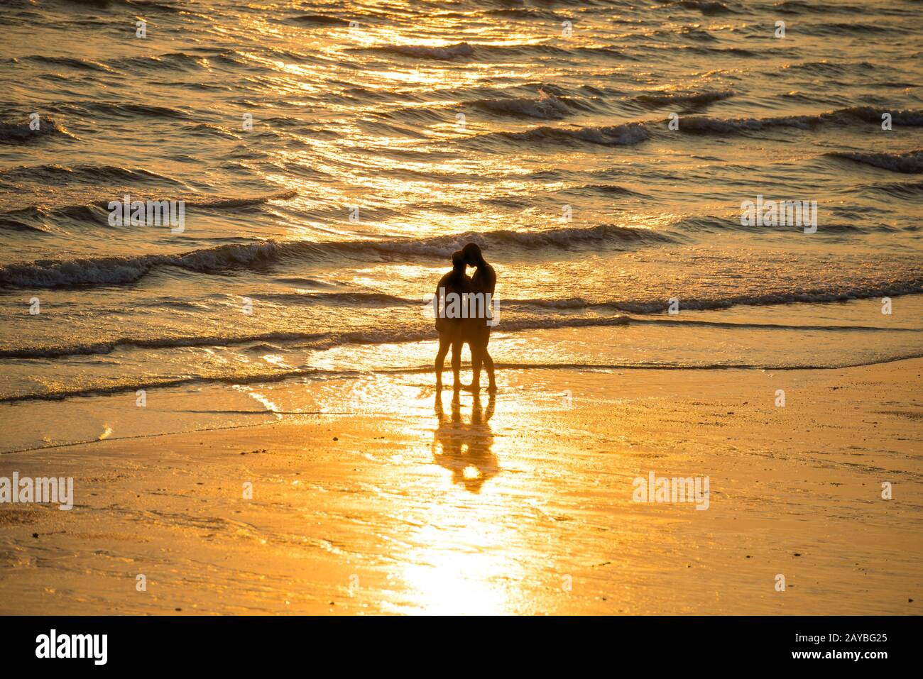 Silhouettes of people on beach at sunset Stock Photo - Alamy