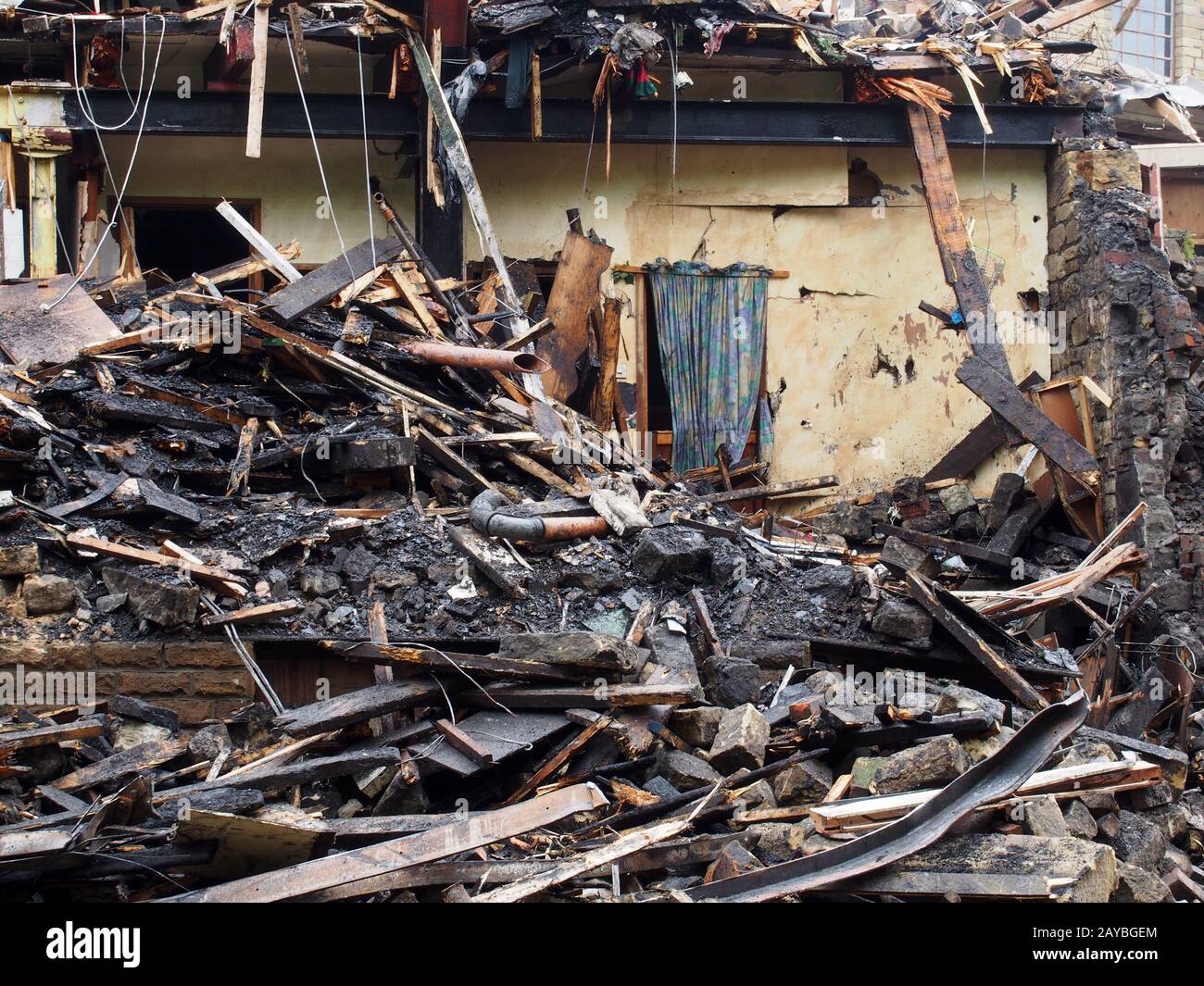 black burned timbers and walls in a collapsed house destroyed by fire Stock Photo